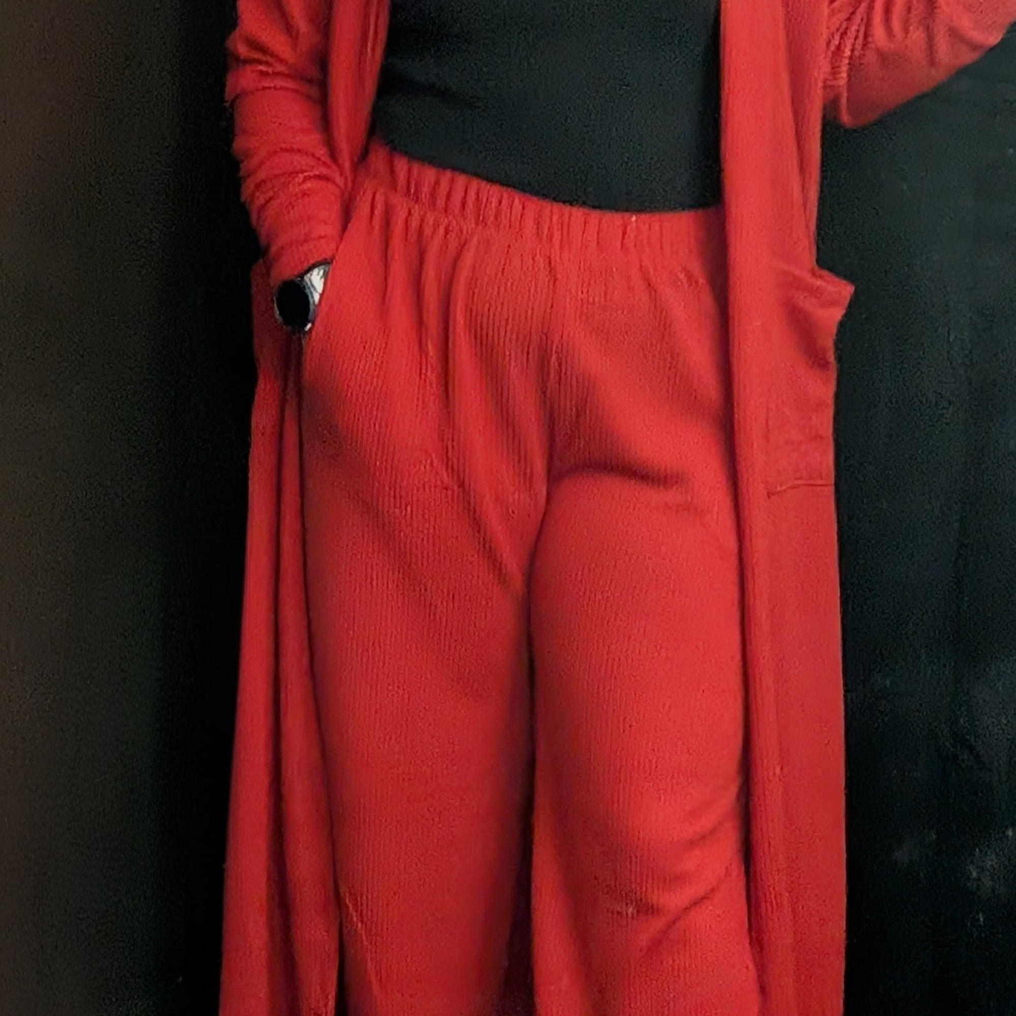 Person wearing a red cardigan and matching pants over a black top