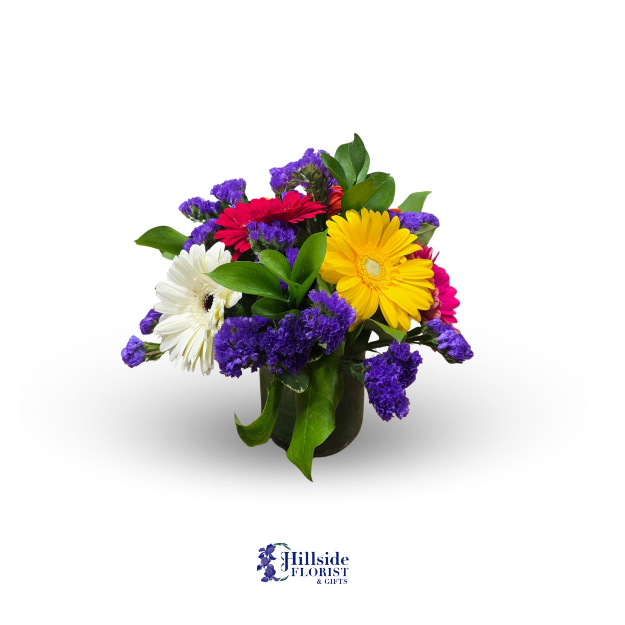 Short bouquet of yellow, red, pink, and white gerbera daisies with purple filler in a glass vase