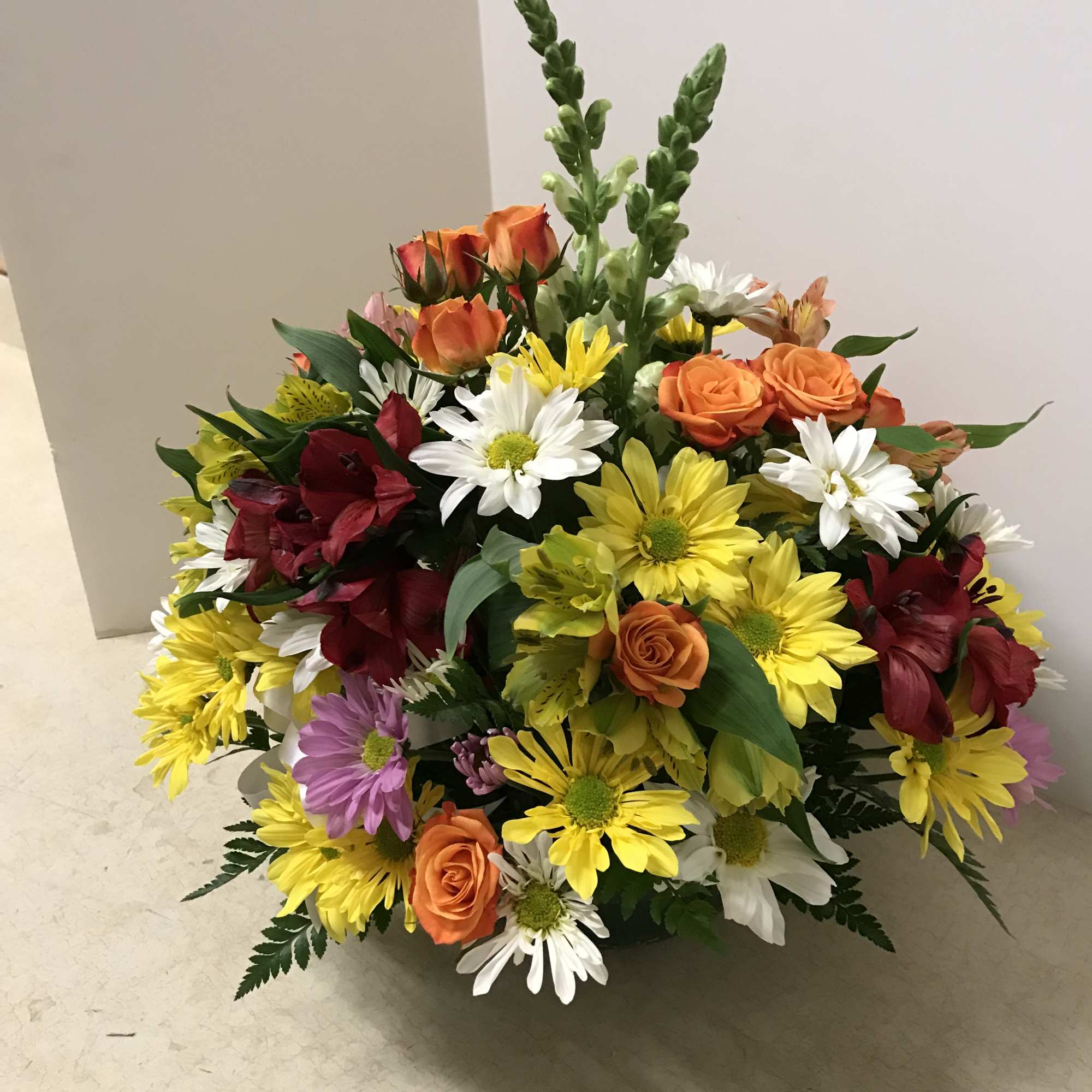 Mixed bouquet of orange roses, daisies, and red lilies