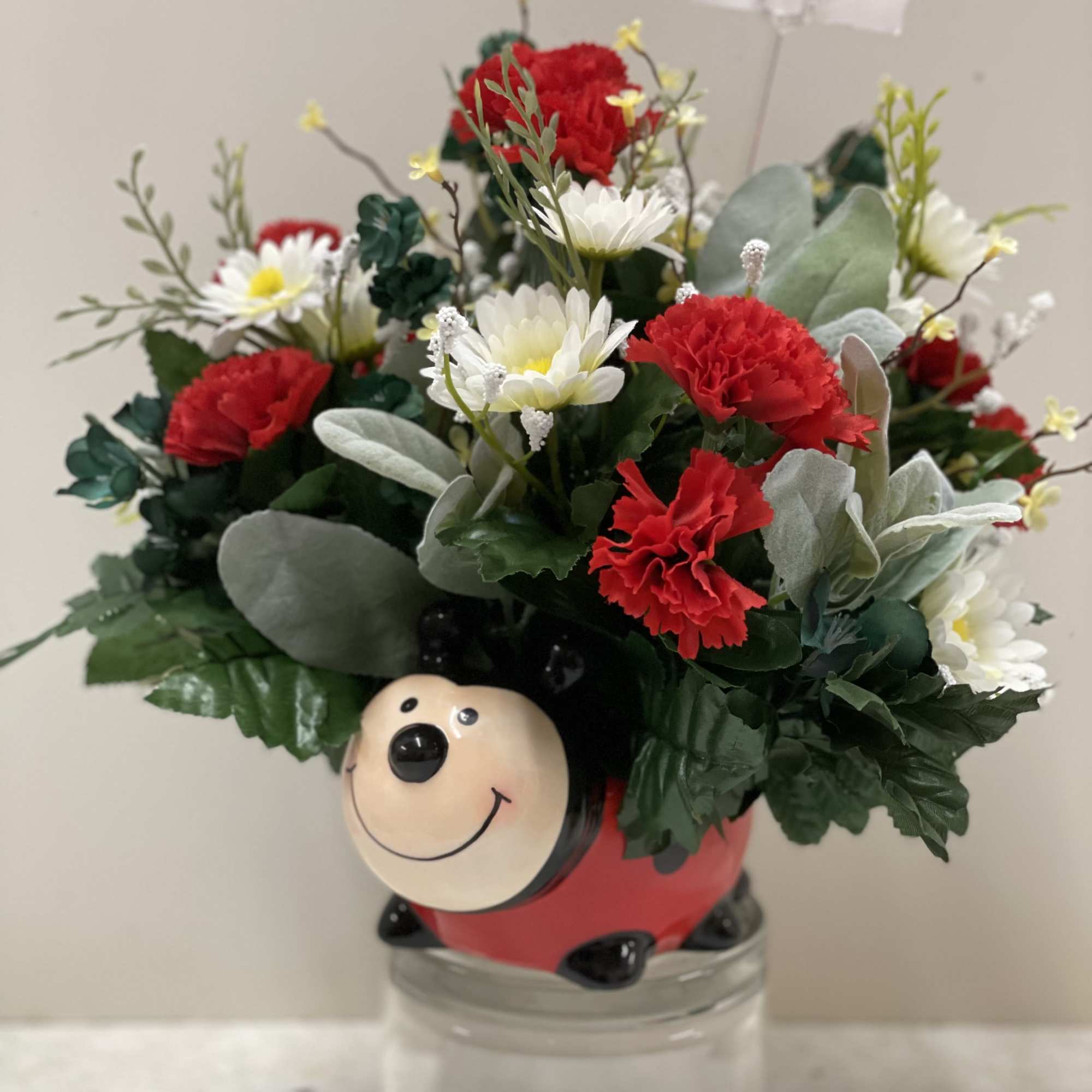 Bouquet of red carnations and white daisies in a ladybug container, photo 2 of 4