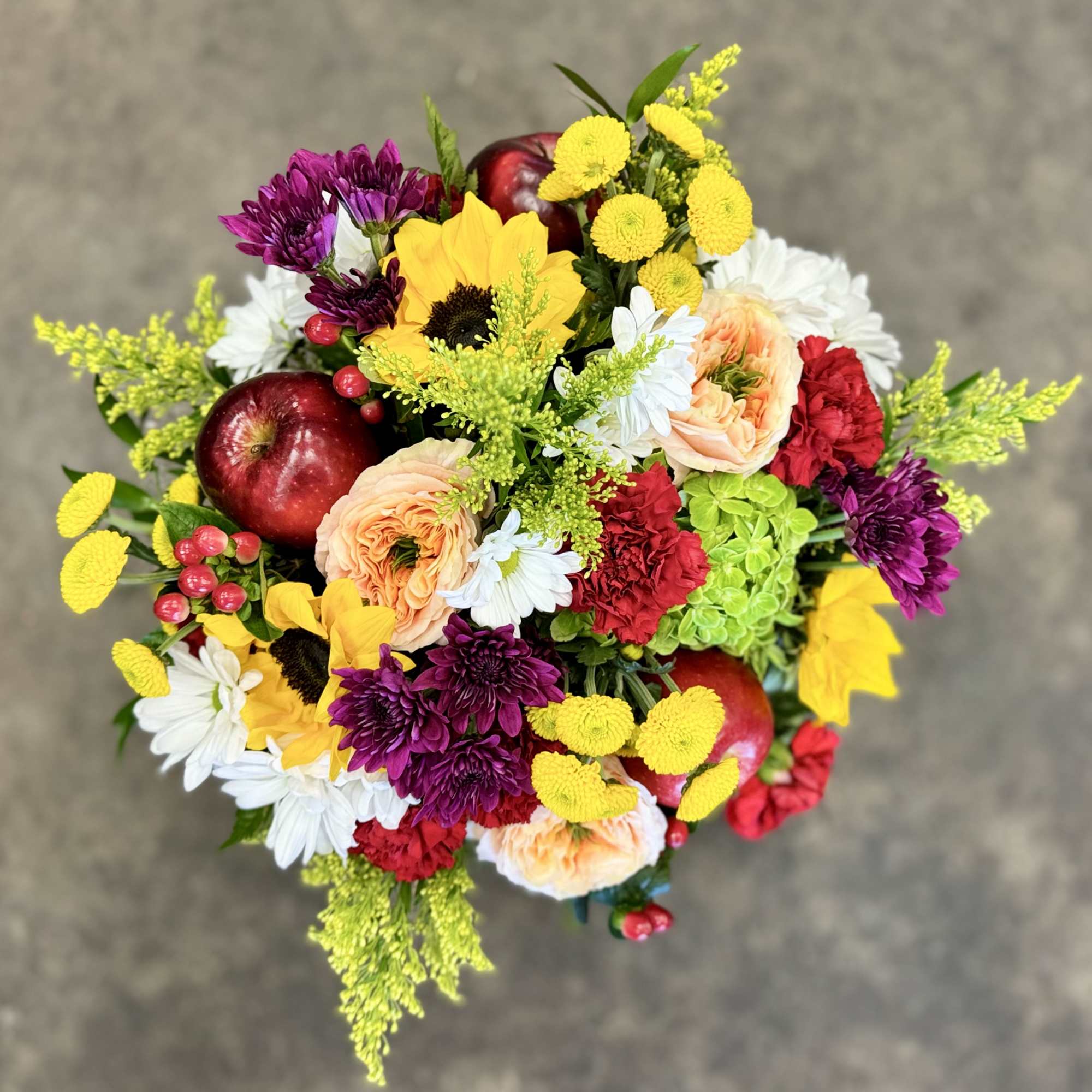 Mixed bouquet with sunflowers, chrysanthemums, roses, and apples