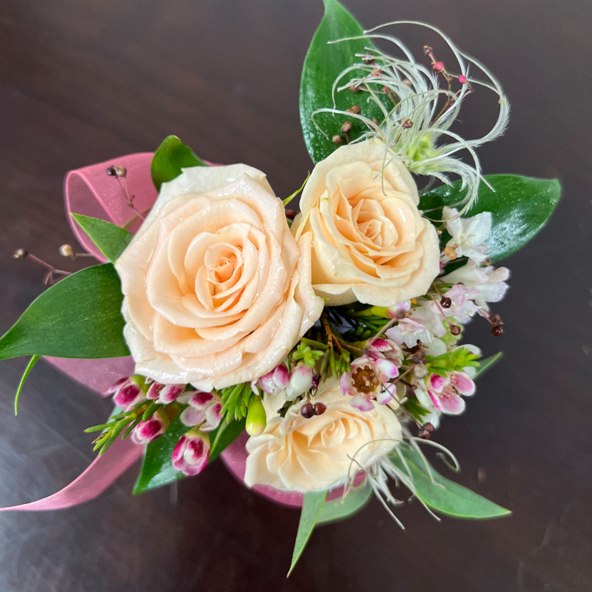 Peach roses with small pink-and-white flowers and ribbon wrap