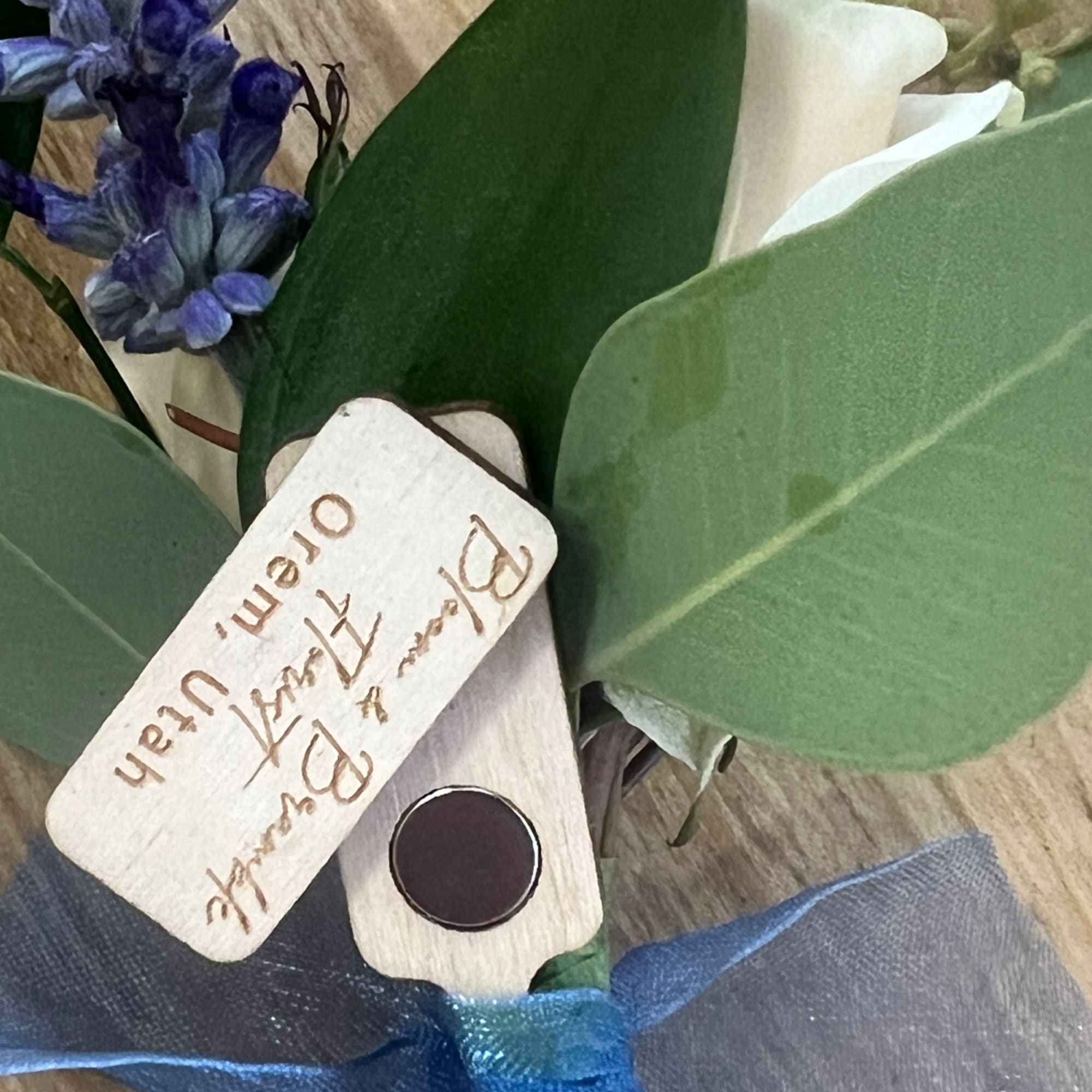 Bouquet with blue flowers, white calla lilies, and large green leaves