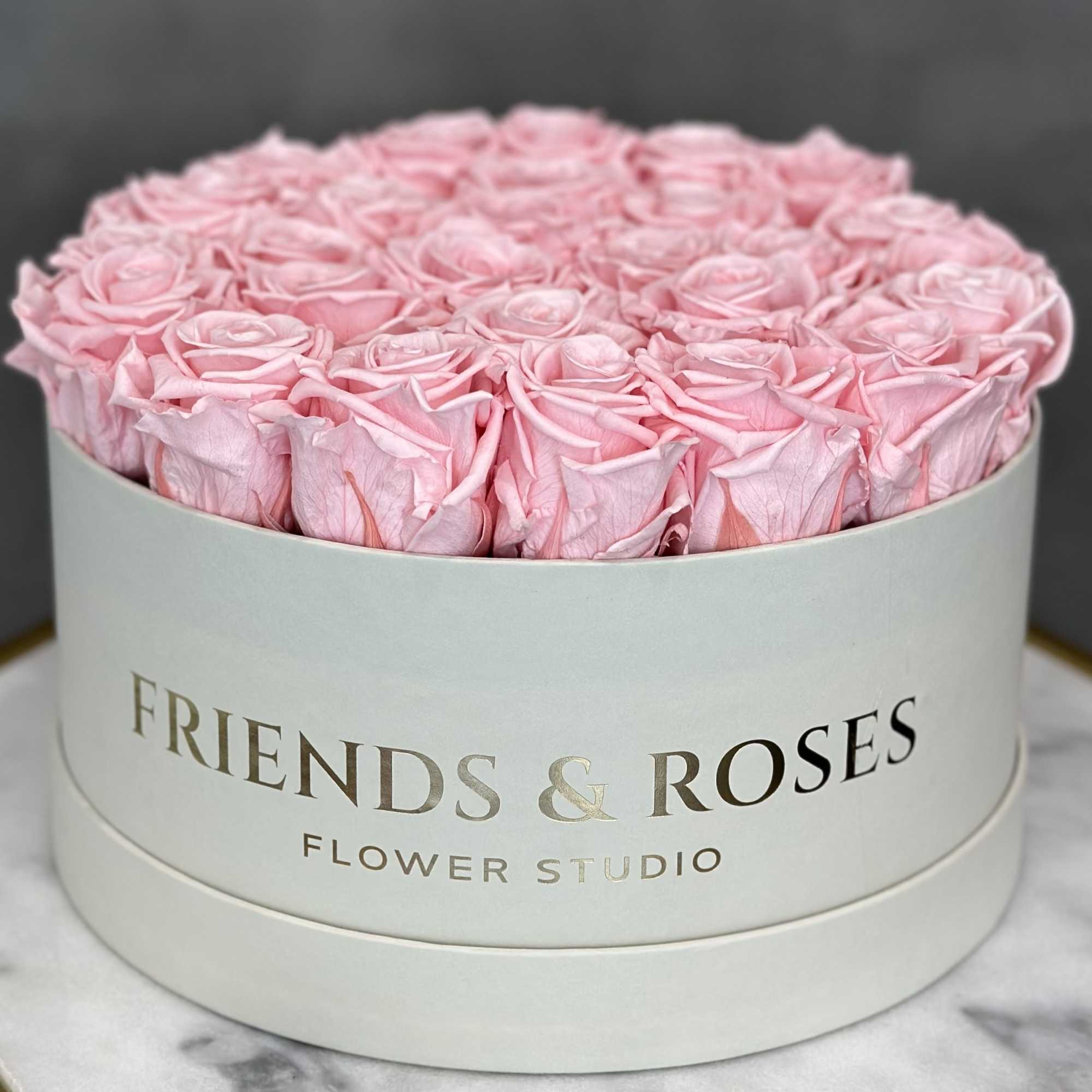Round box of pink roses with a printed logo