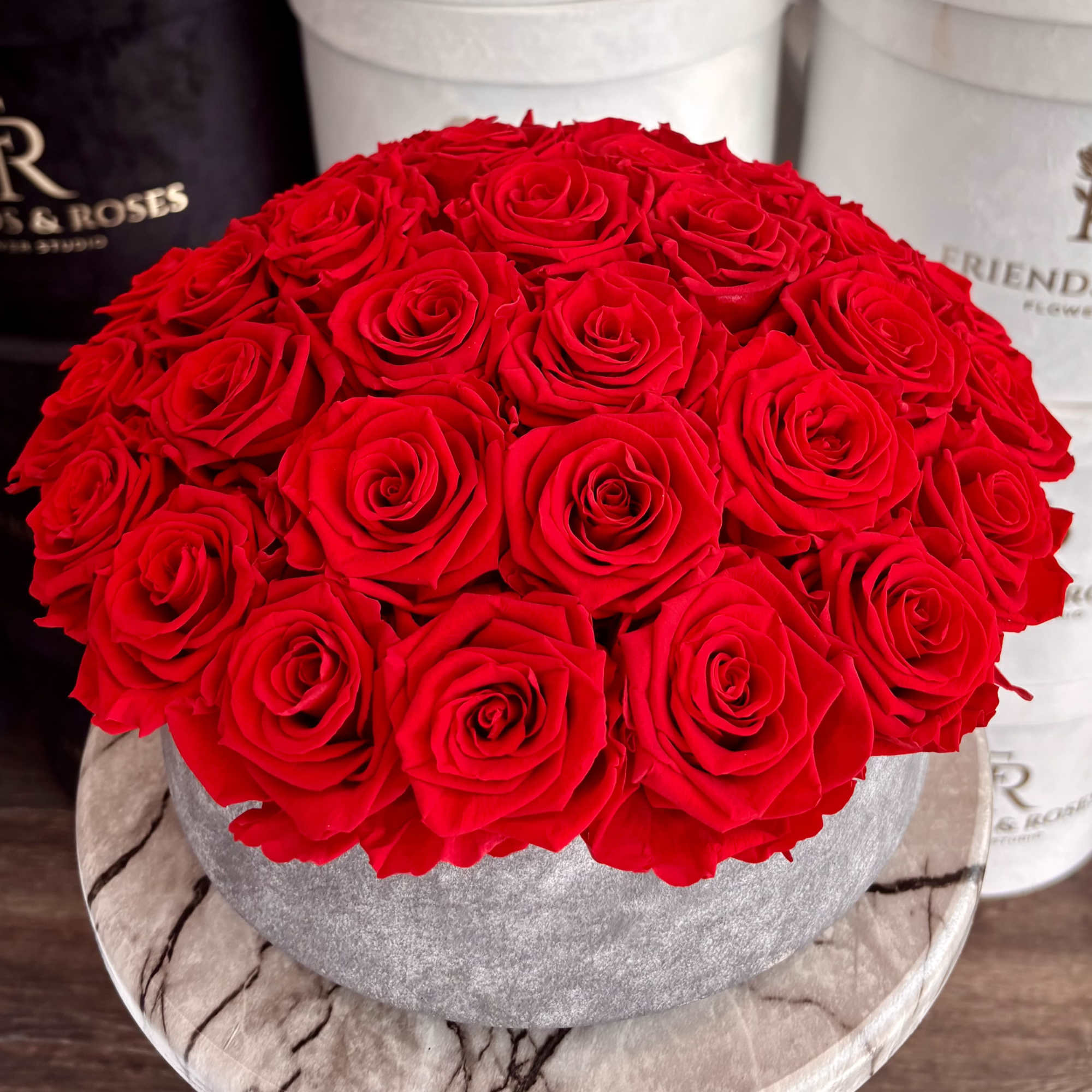 Round bouquet of red roses in a gray hatbox