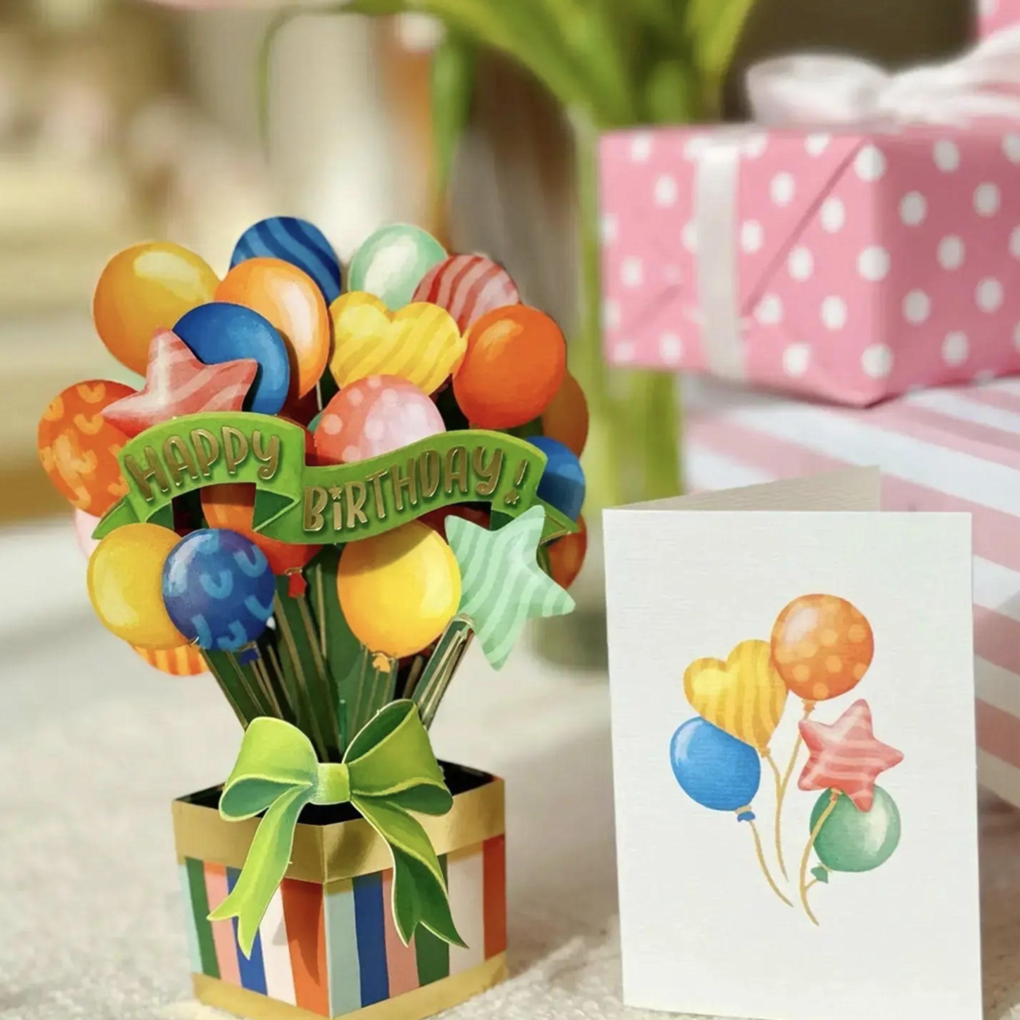 Birthday balloon bouquet in a striped gift box with a greeting card
