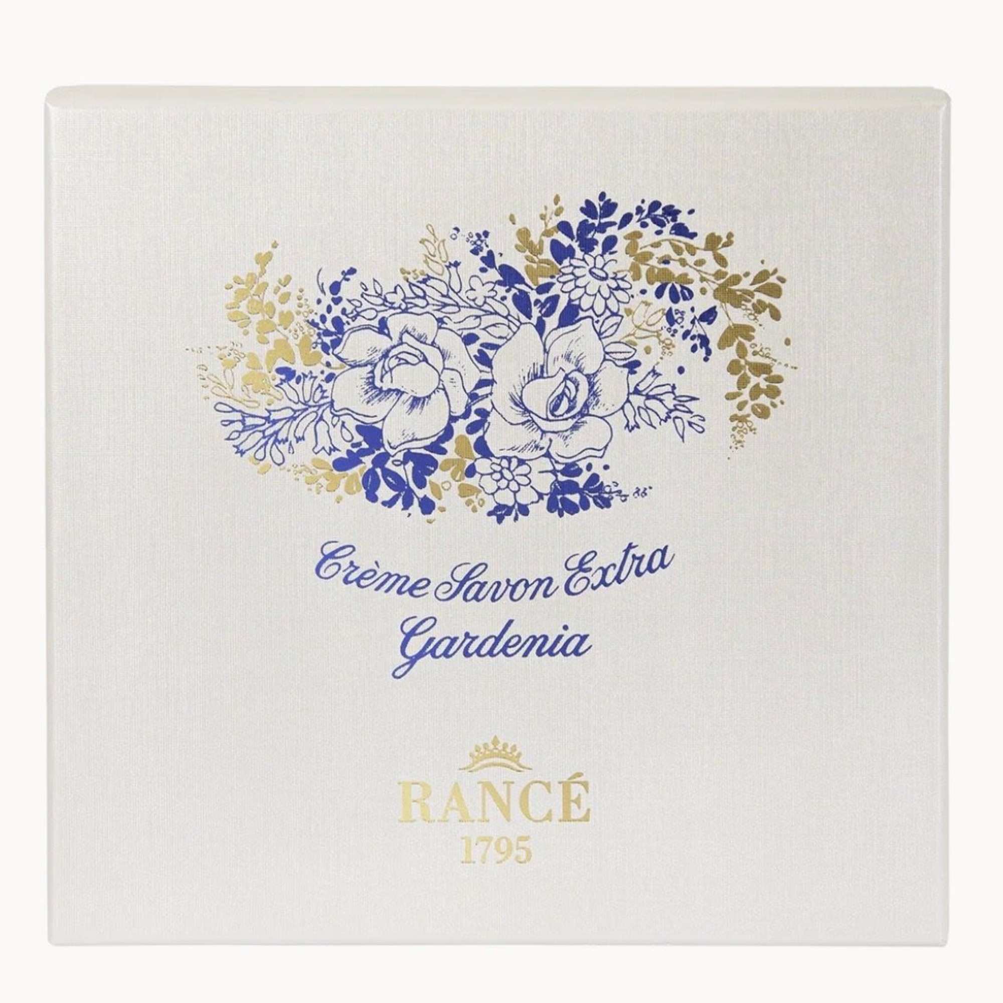 Square soap box with blue and gold floral illustration and text