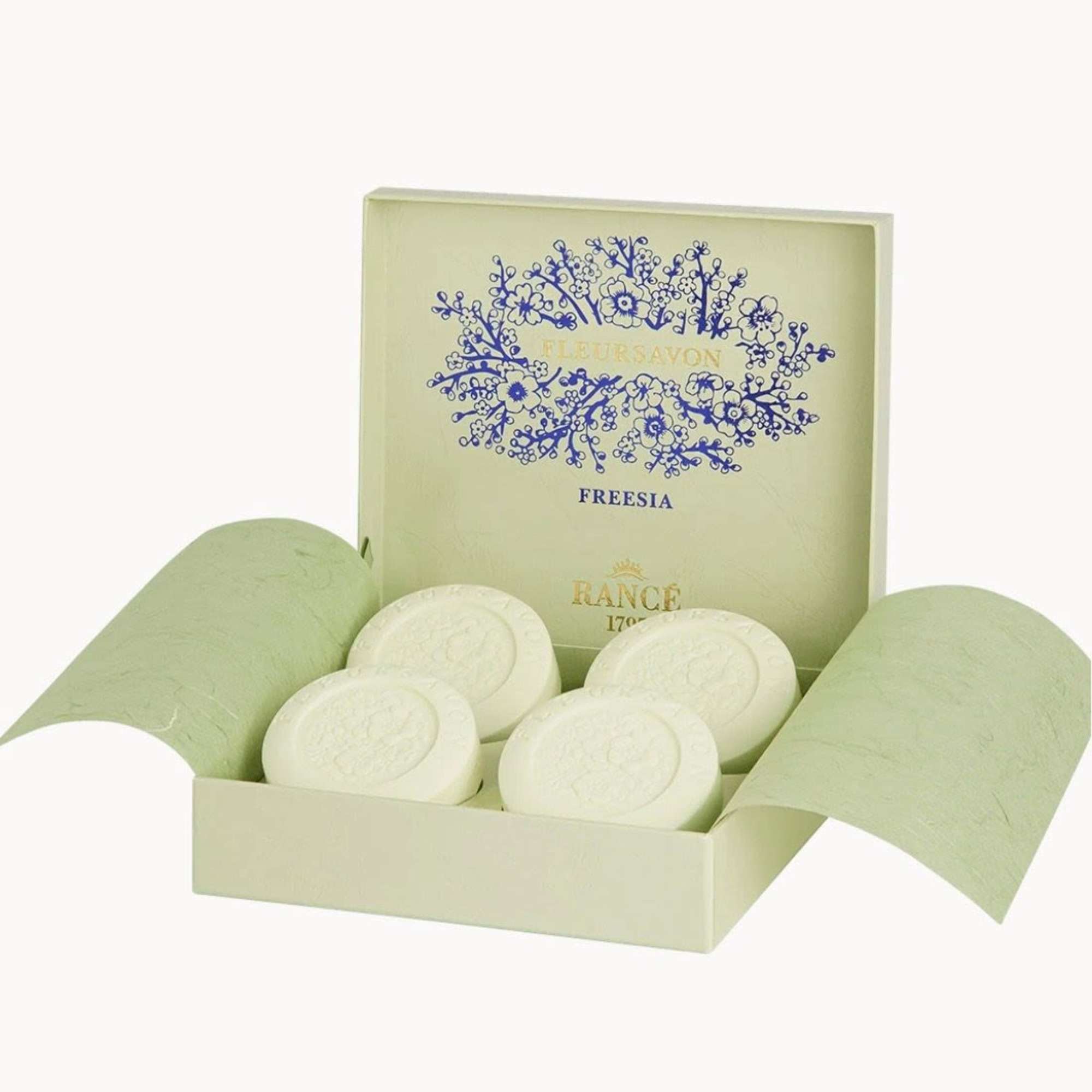 Open gift box with round white soaps and freesia branding