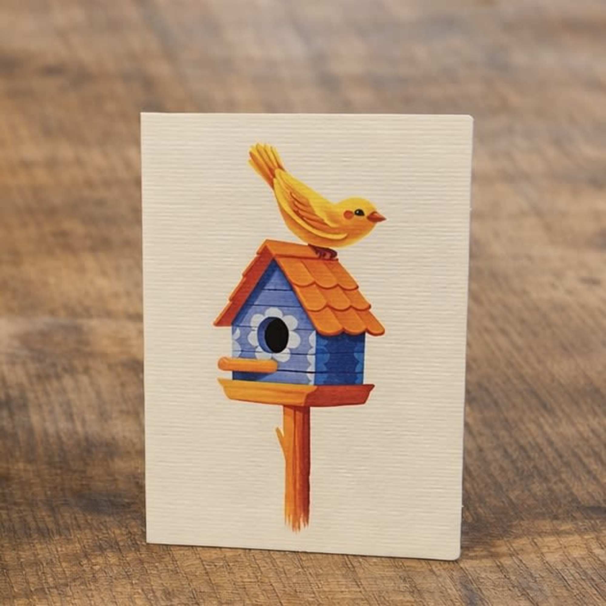 Greeting card with a colorful birdhouse and yellow bird illustration