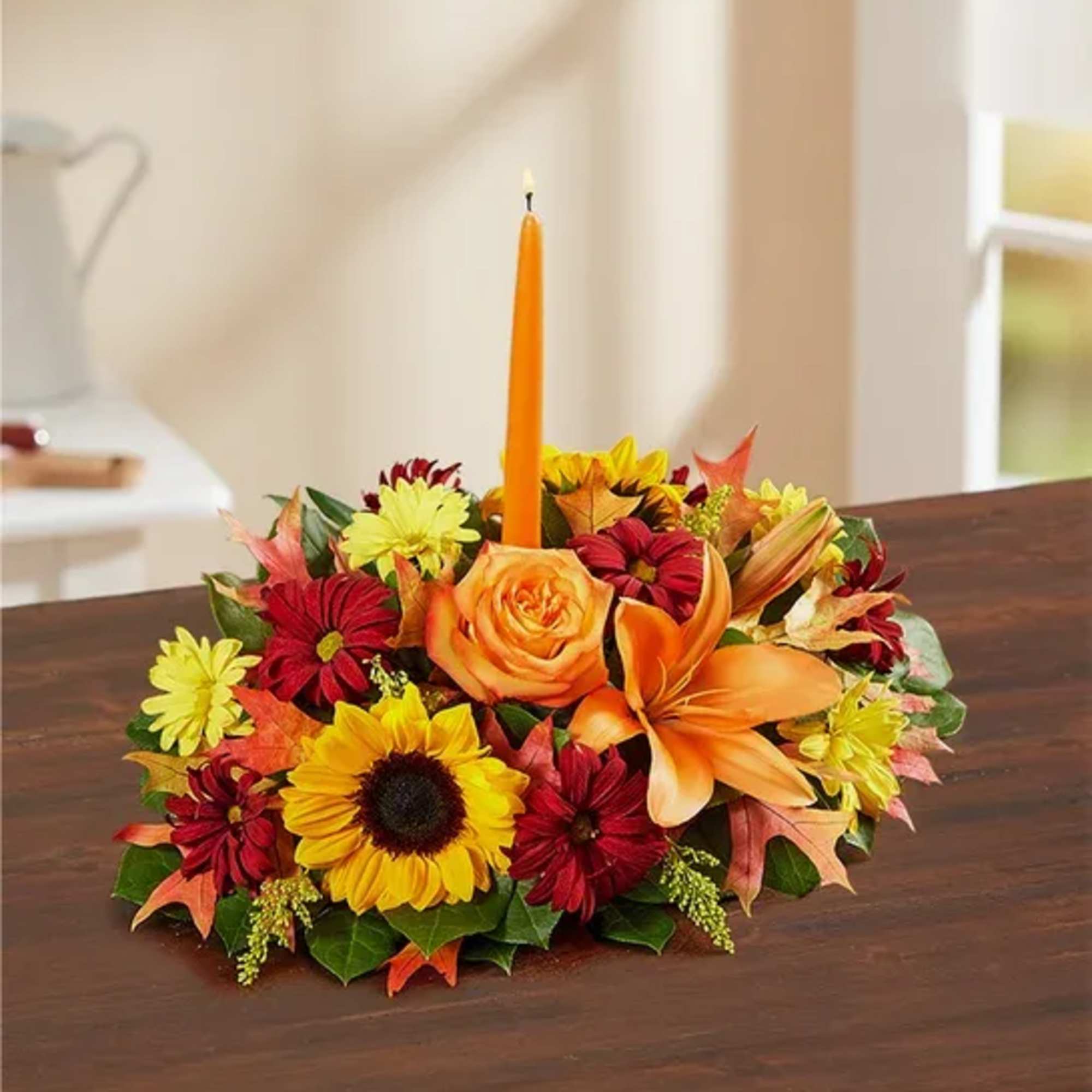 Autumn floral centerpiece with a tall orange candle
