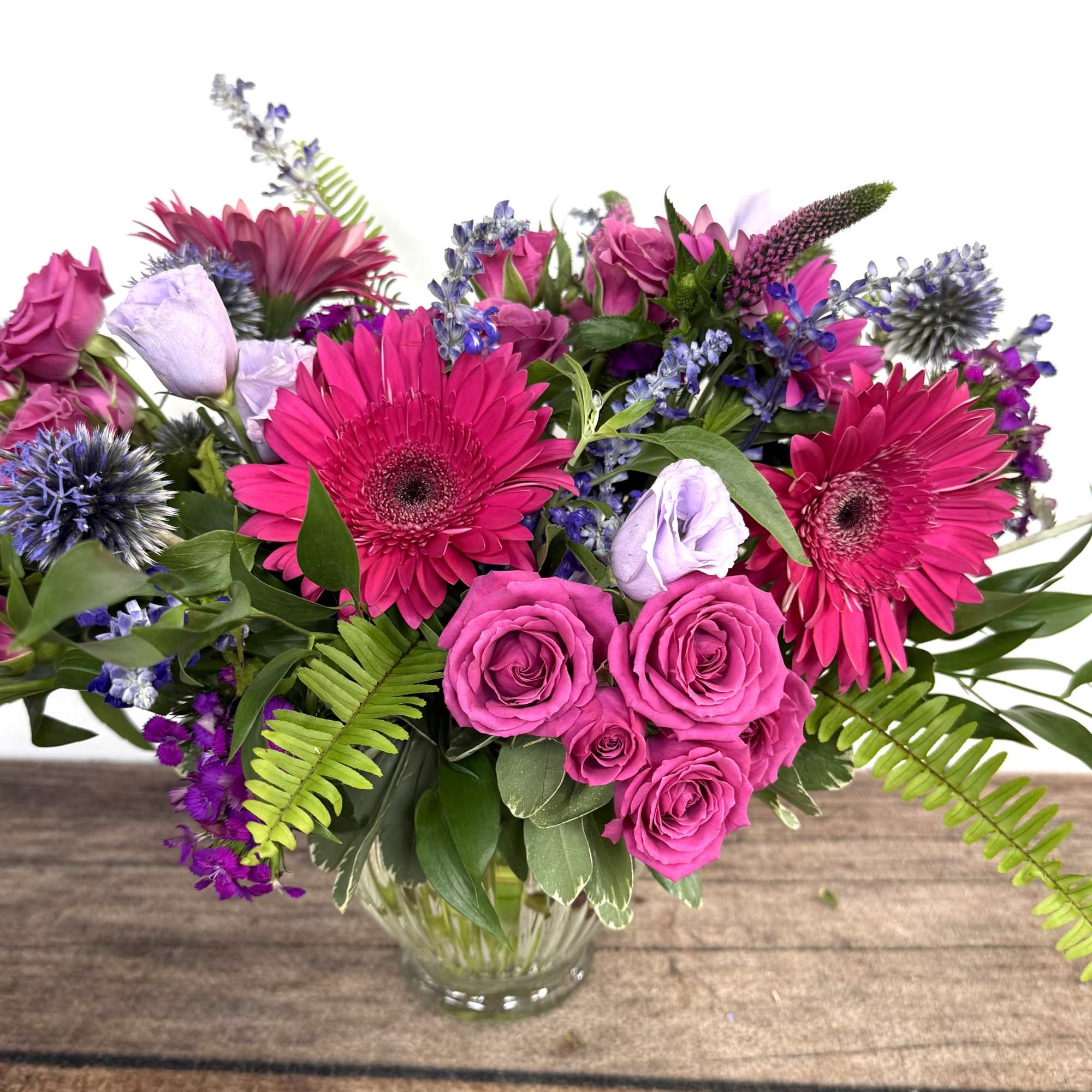 Bright pink and purple mixed bouquet in a clear glass vase