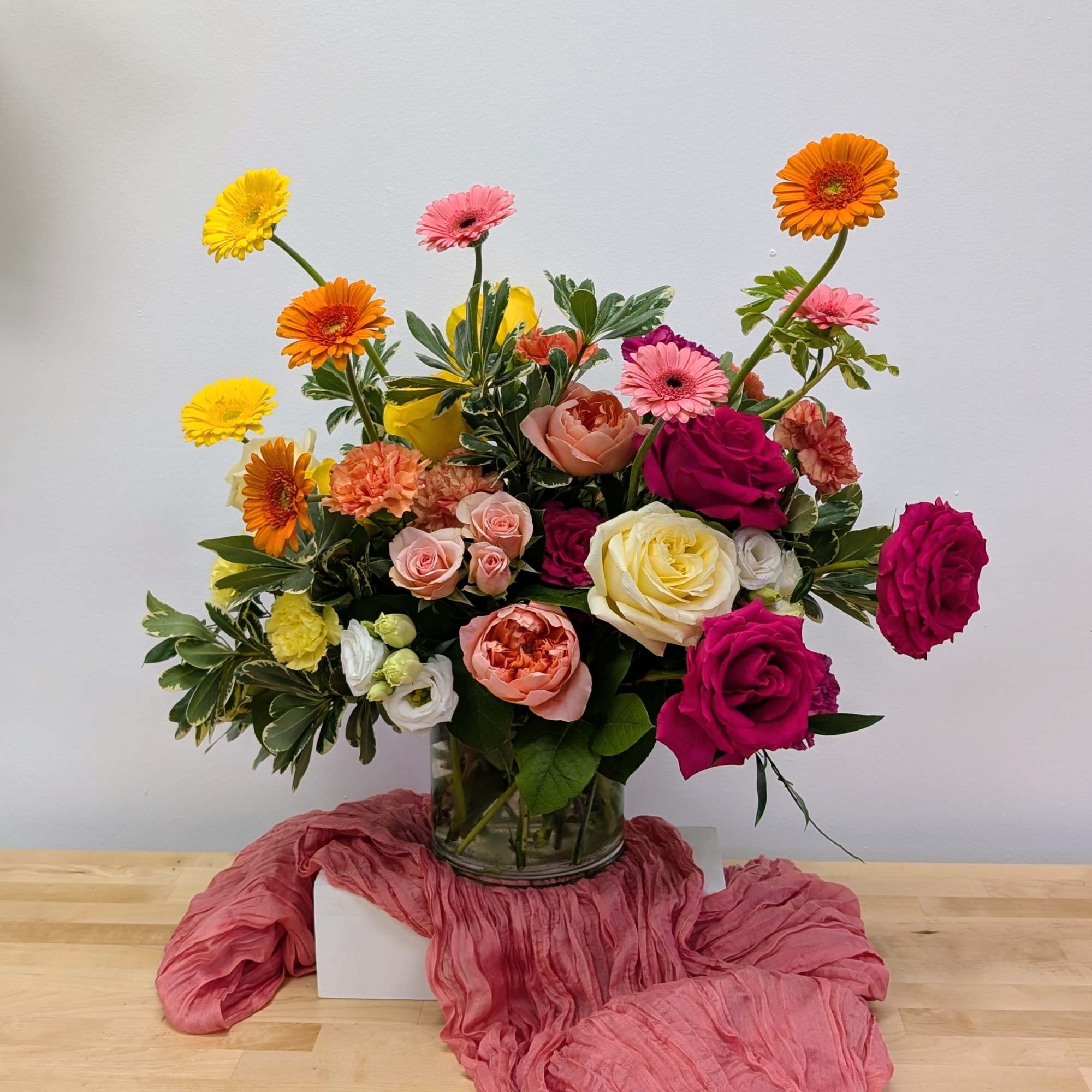 Mixed bouquet of roses and gerbera daisies in a glass vase