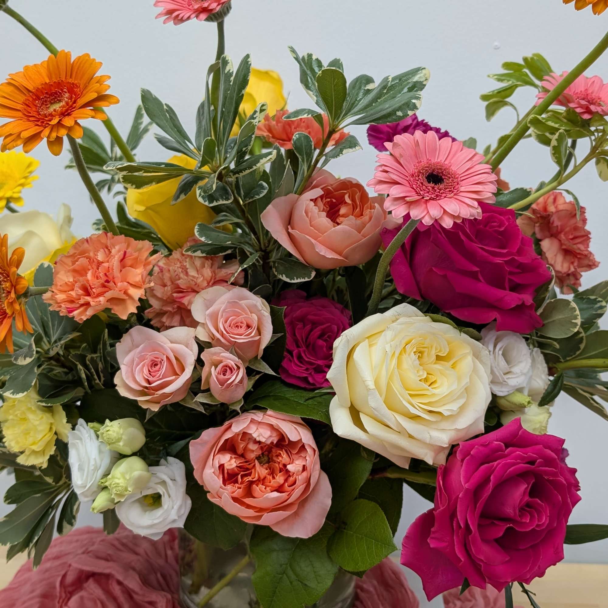 Mixed bouquet of roses, gerbera daisies, and carnations in a glass vase, photo 2 of 6