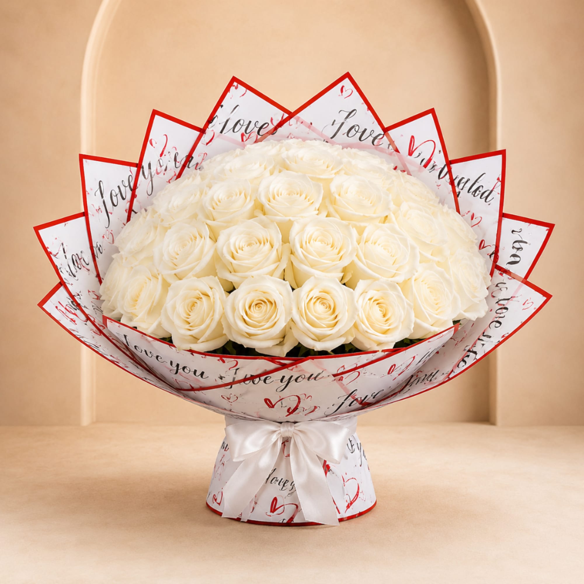 Bouquet of white roses wrapped in printed paper with a white ribbon