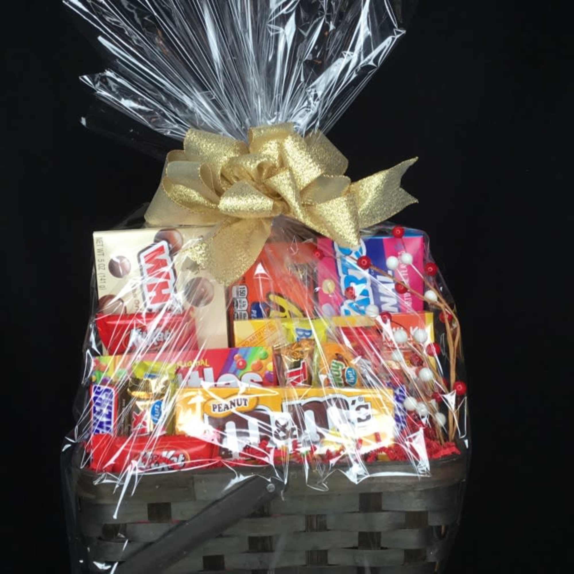 Gift basket of assorted candy bars wrapped in clear cellophane with a gold bow