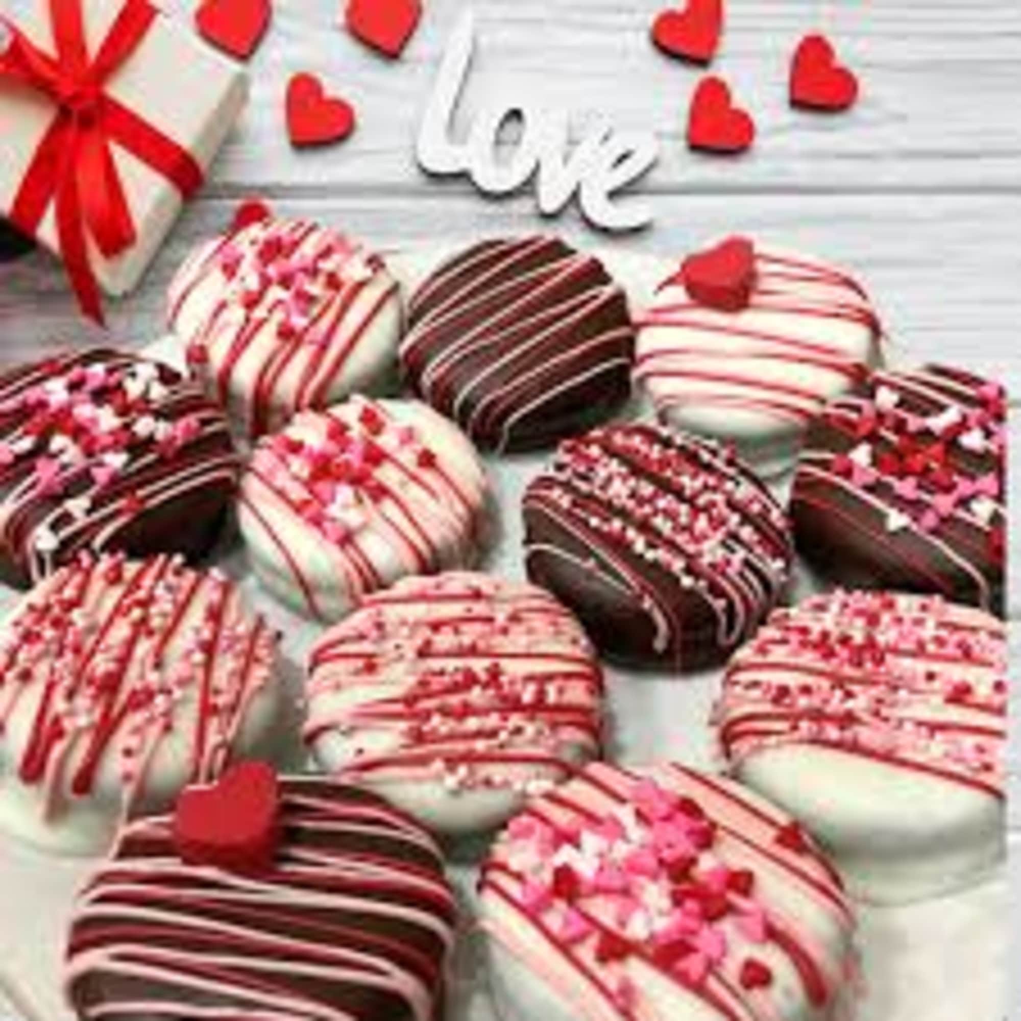Box of chocolate-covered treats decorated with red and pink drizzle and hearts