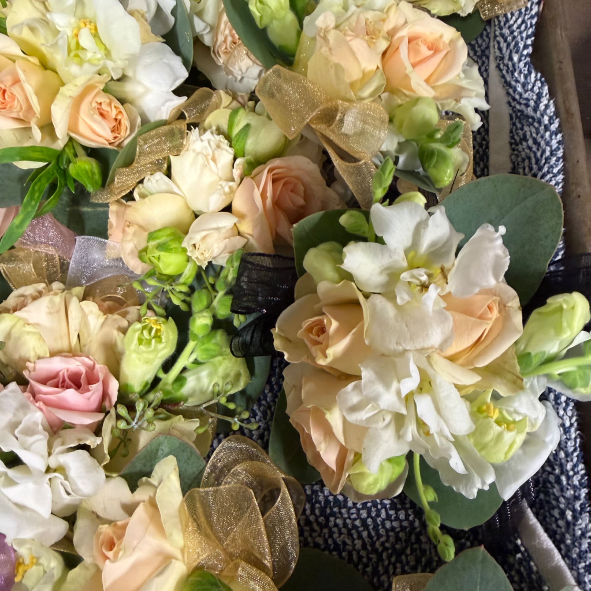 Small bouquets of peach and white roses with white orchids and ribbon bows