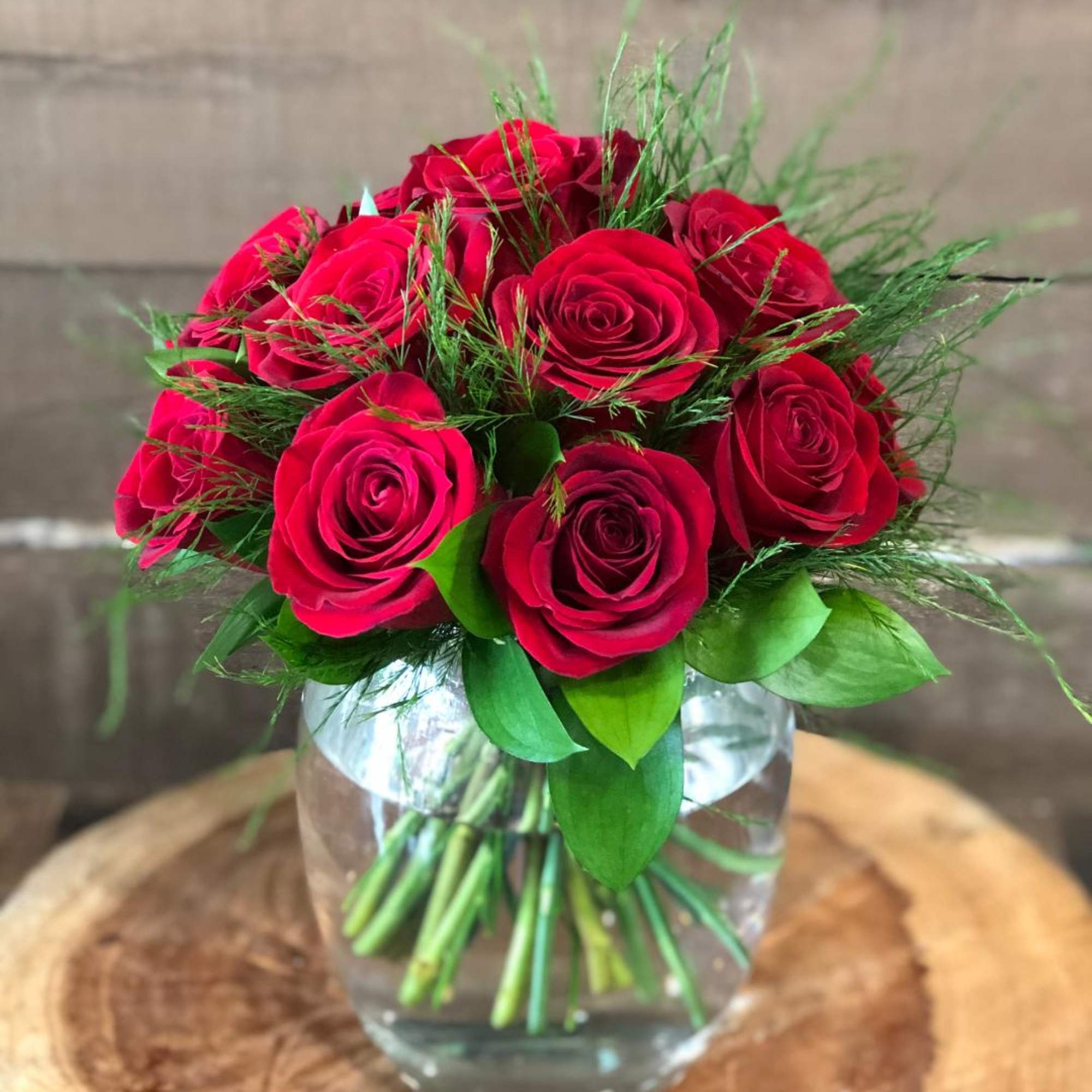 Red roses arranged in a clear glass vase