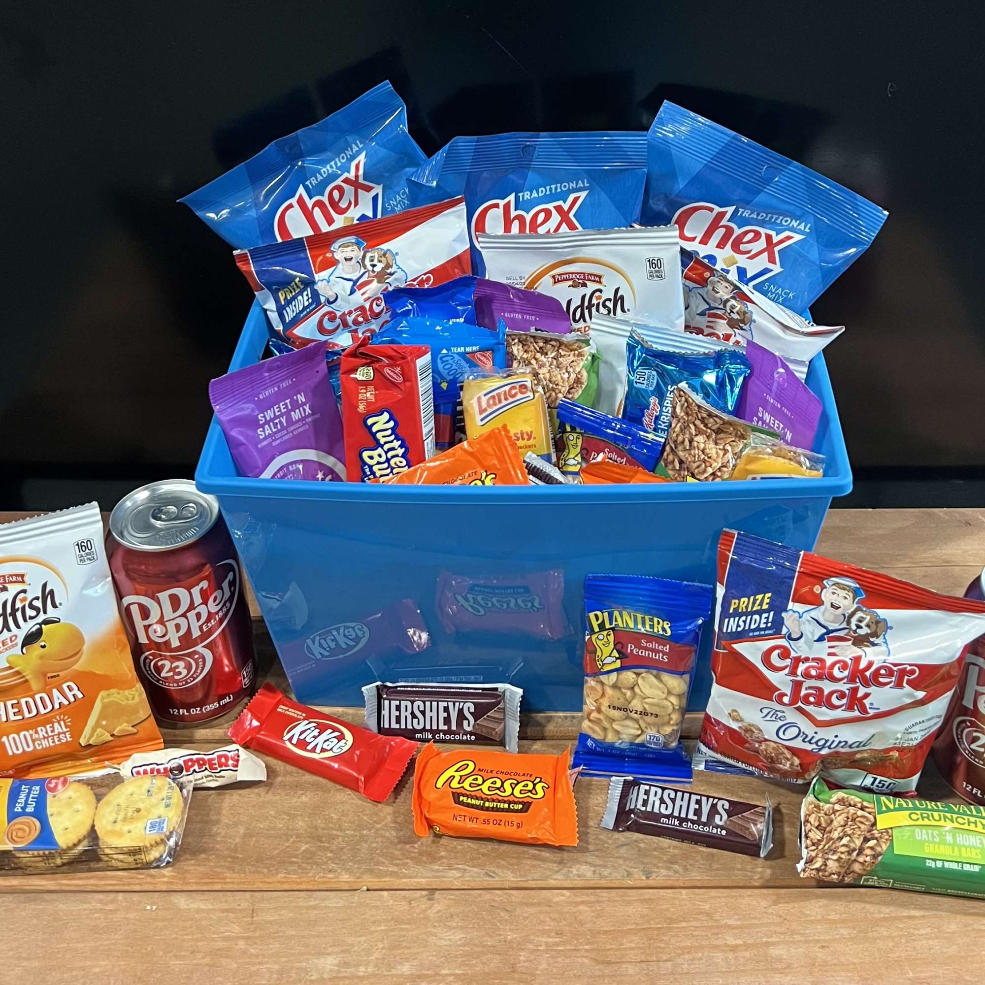 Snack gift basket with chips, candy, and soda in a blue bin