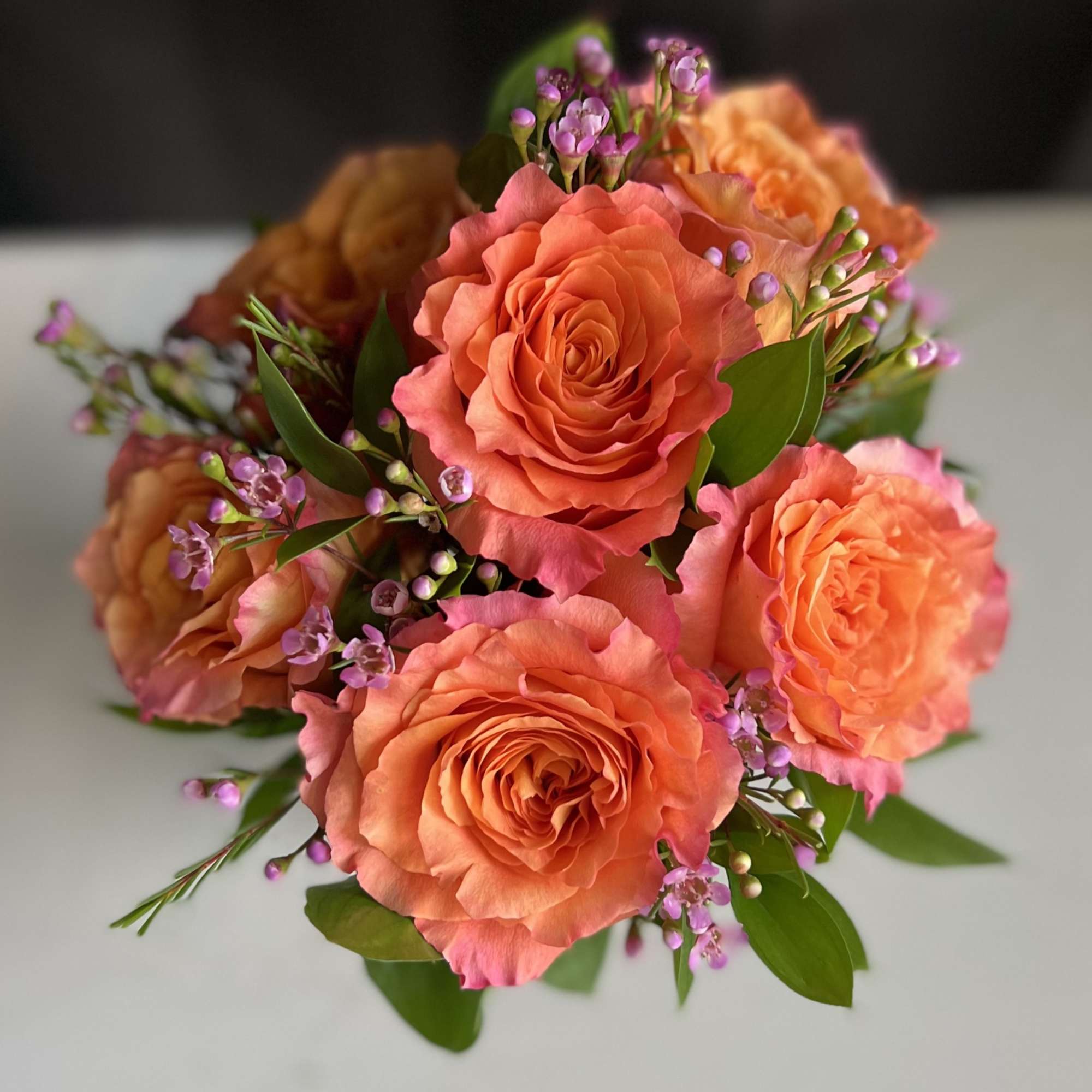 Bouquet of peach roses with small purple filler flowers