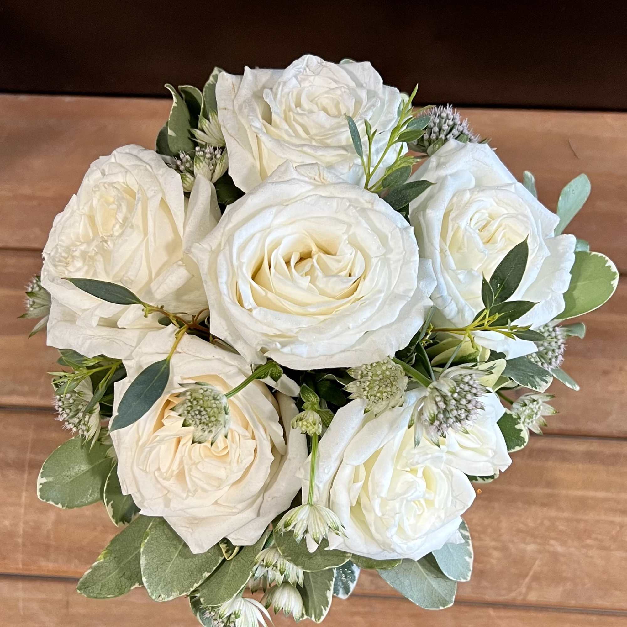 Bouquet of white roses with small filler flowers and greenery