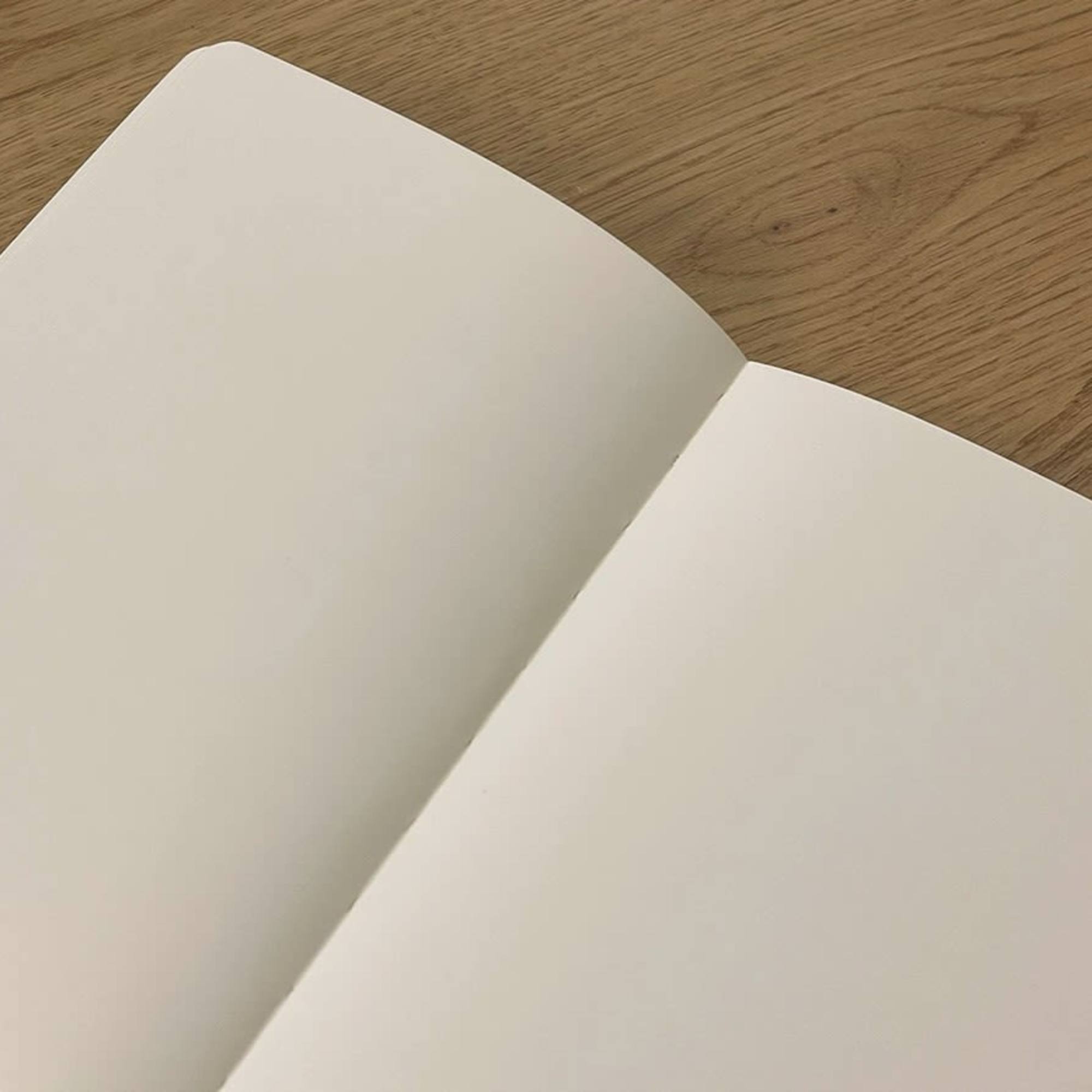 Open blank cream-colored card on a wooden surface