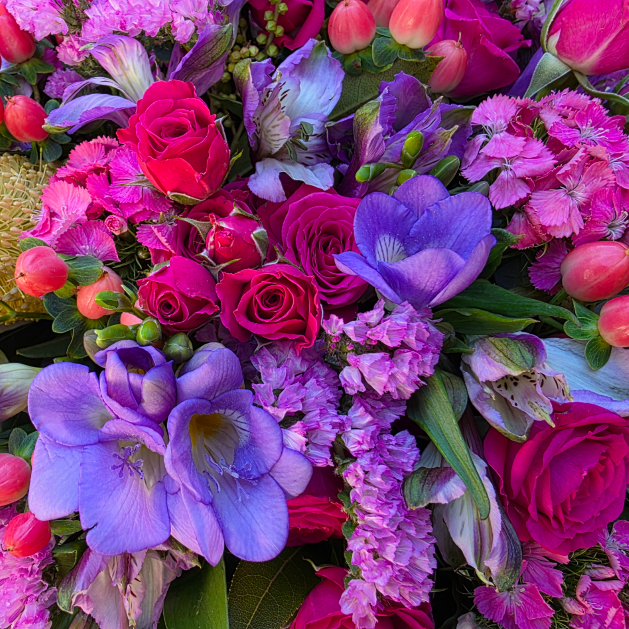 Bouquet of pink roses and purple flowers with small tulip buds
