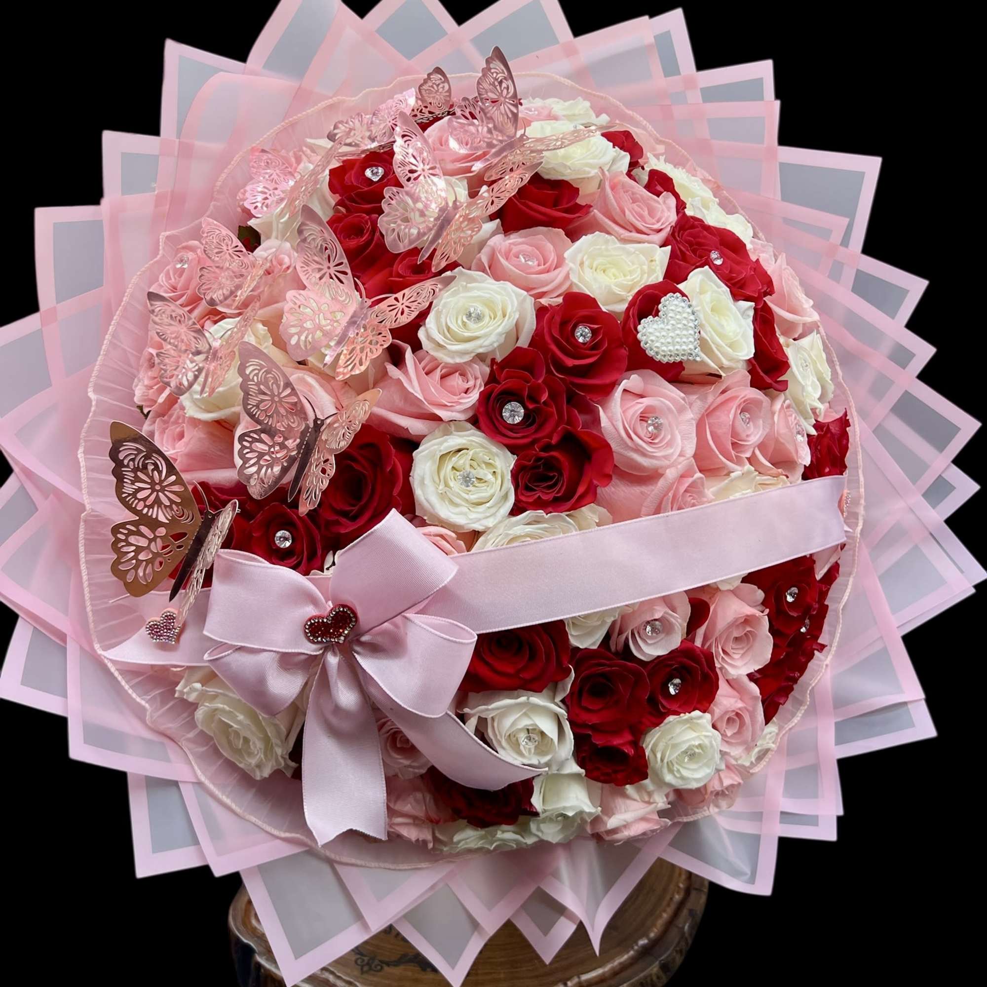 Pink and red rose bouquet with butterflies and a ribbon bow