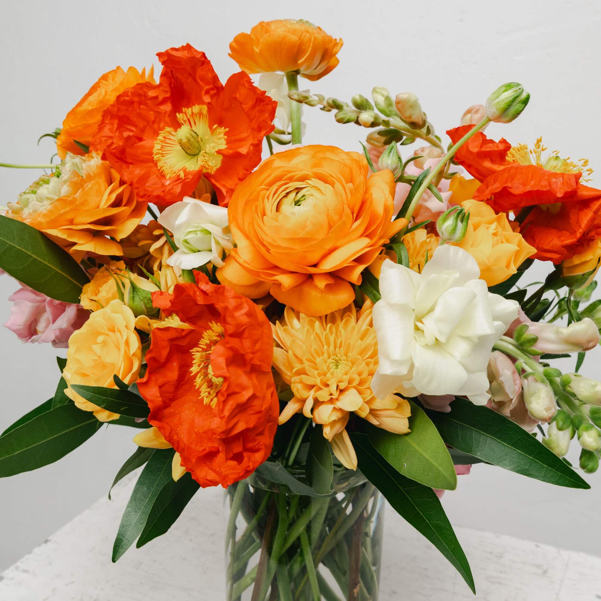 Orange and white mixed bouquet in a clear glass vase