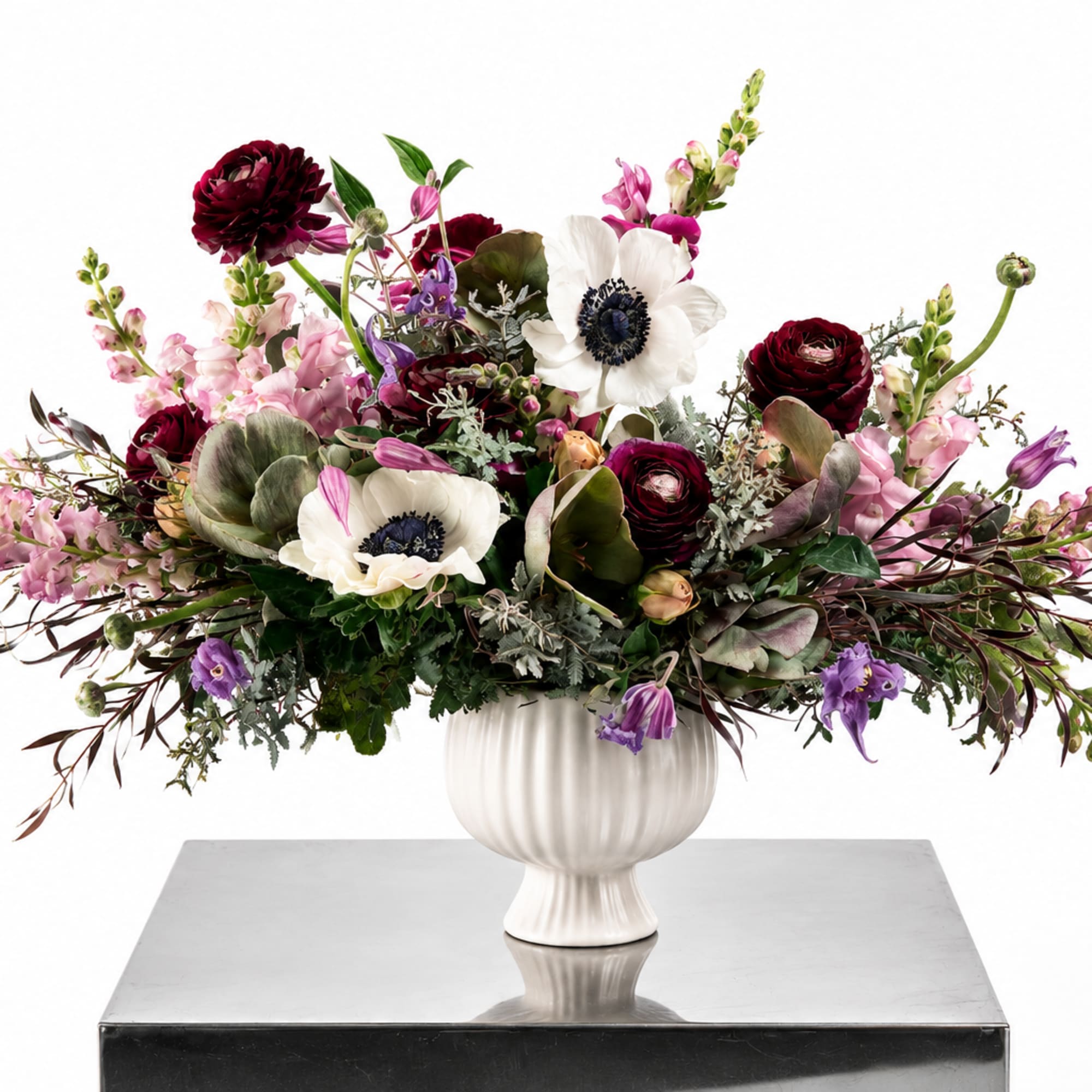 Large mixed floral arrangement in a white pedestal vase