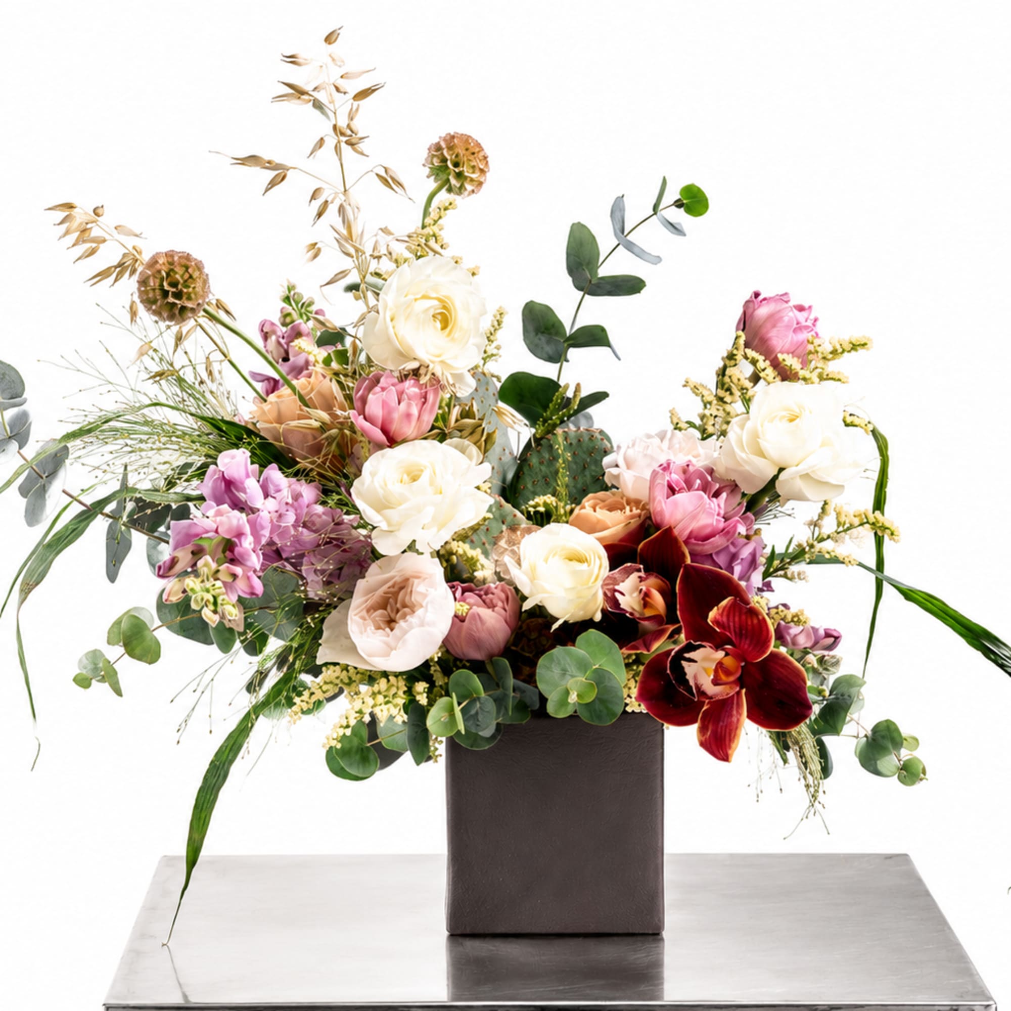 Mixed floral arrangement in a dark square vase with pink, white, and burgundy blooms