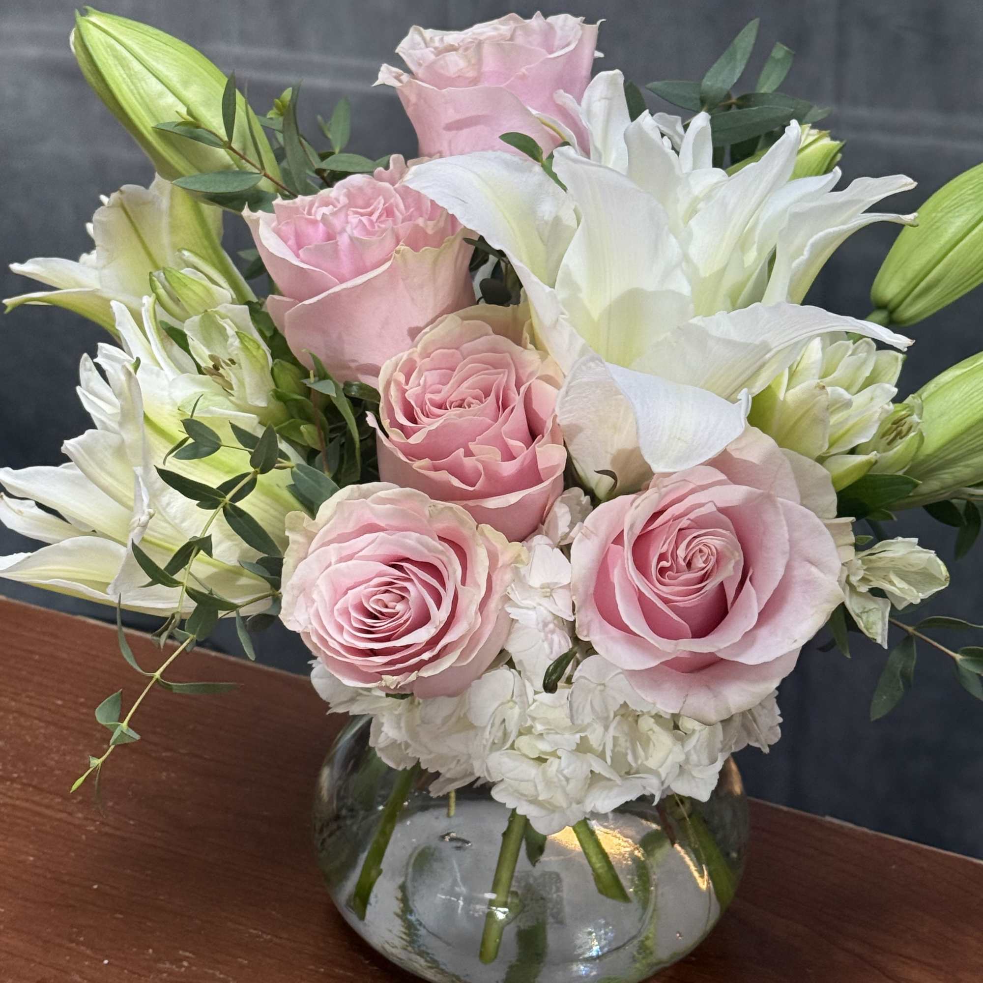A delicate arrangement of white lilies , white alstroemeria ,and fresh pink