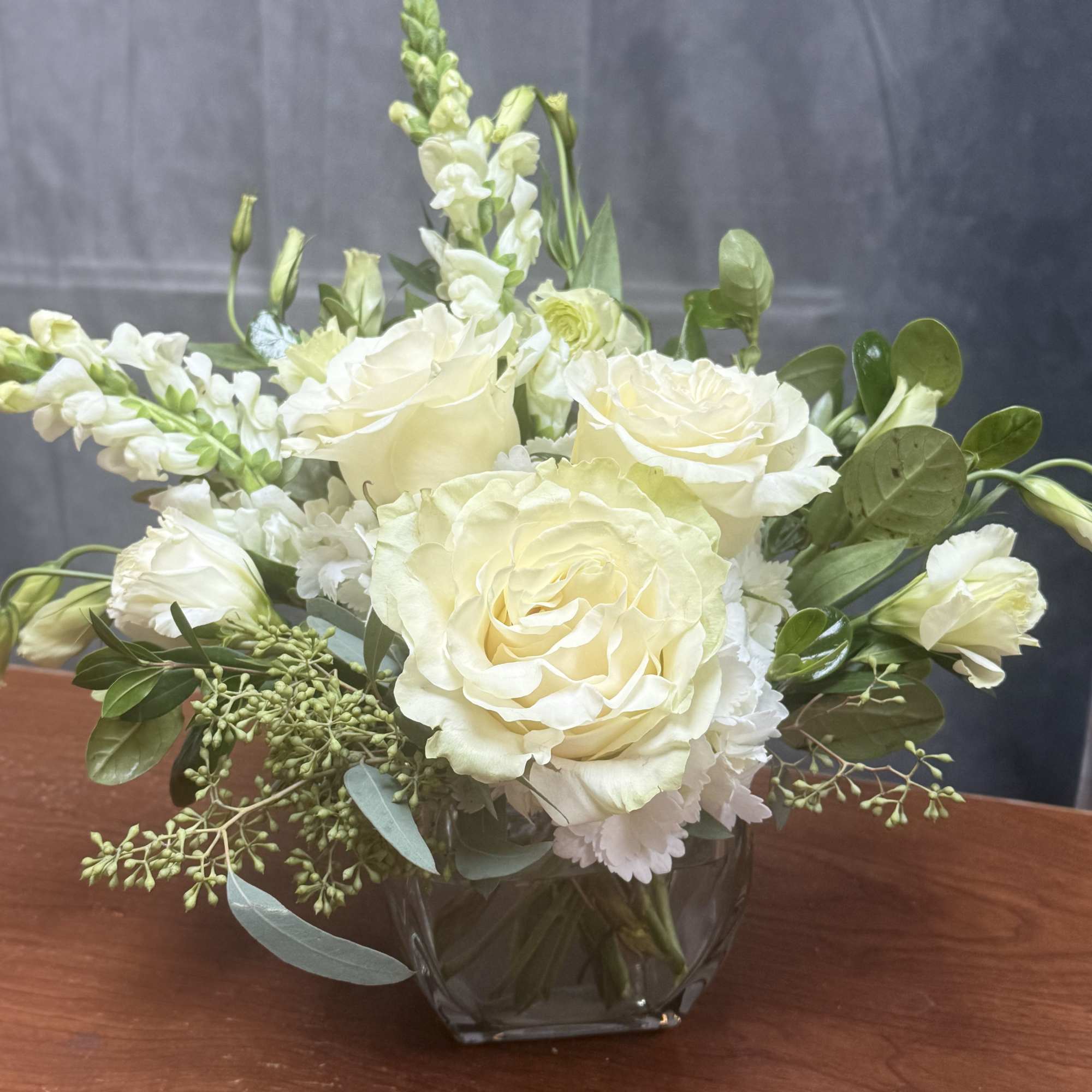 Cream rose bouquet in a clear glass vase