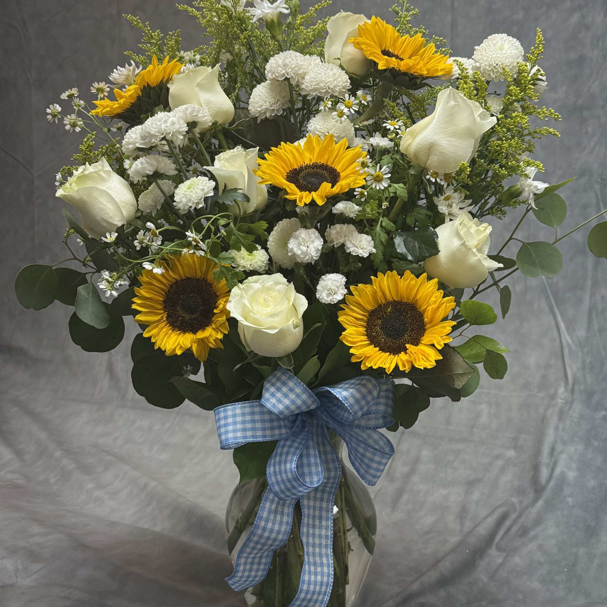 Bouquet of sunflowers and white roses in a glass vase with a blue ribbon, photo 2 of 2