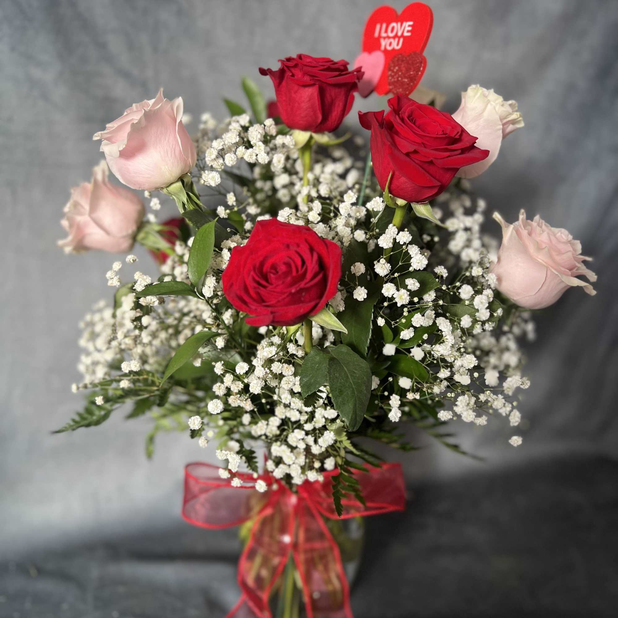 Red and pale pink roses with baby's breath in a glass vase