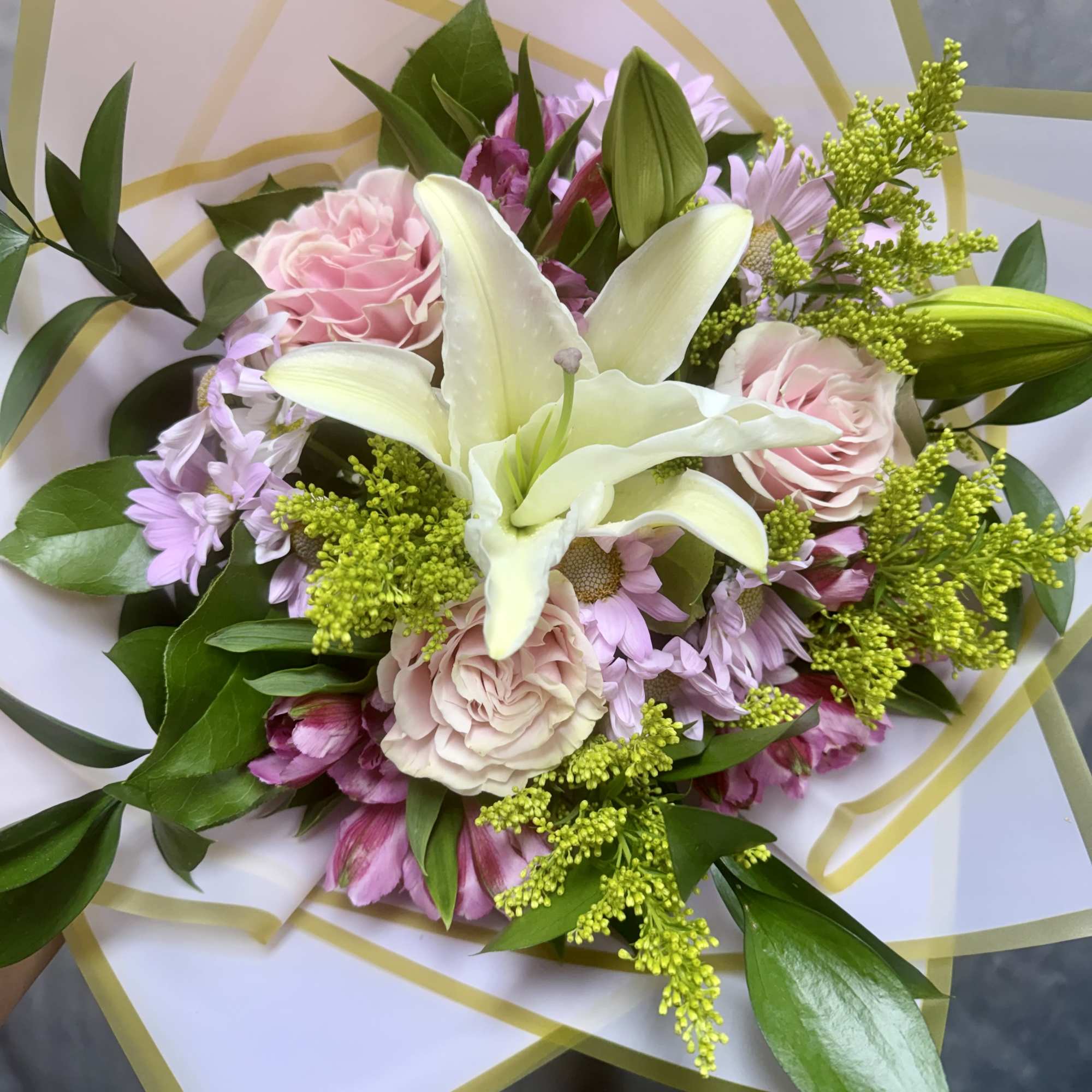 Bouquet of pink and white flowers wrapped in translucent paper