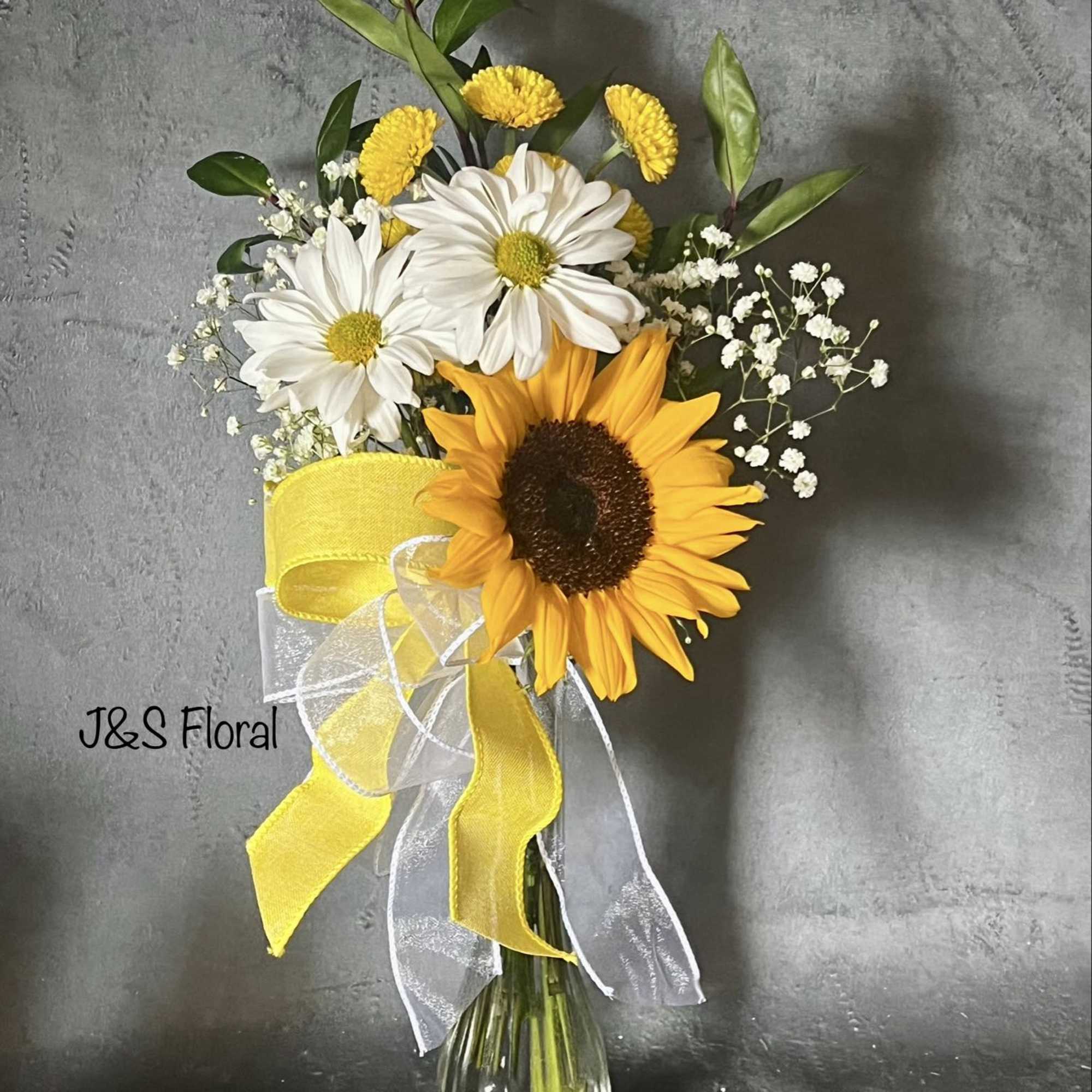 Sunflower and white daisy bouquet in a glass vase with yellow ribbon