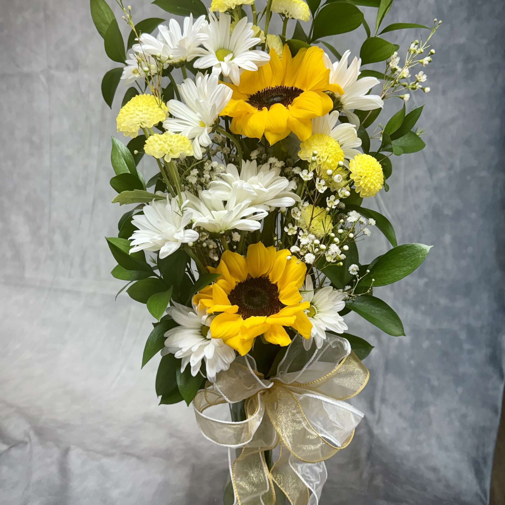 Bouquet of yellow sunflowers and white daisies with a gold ribbon