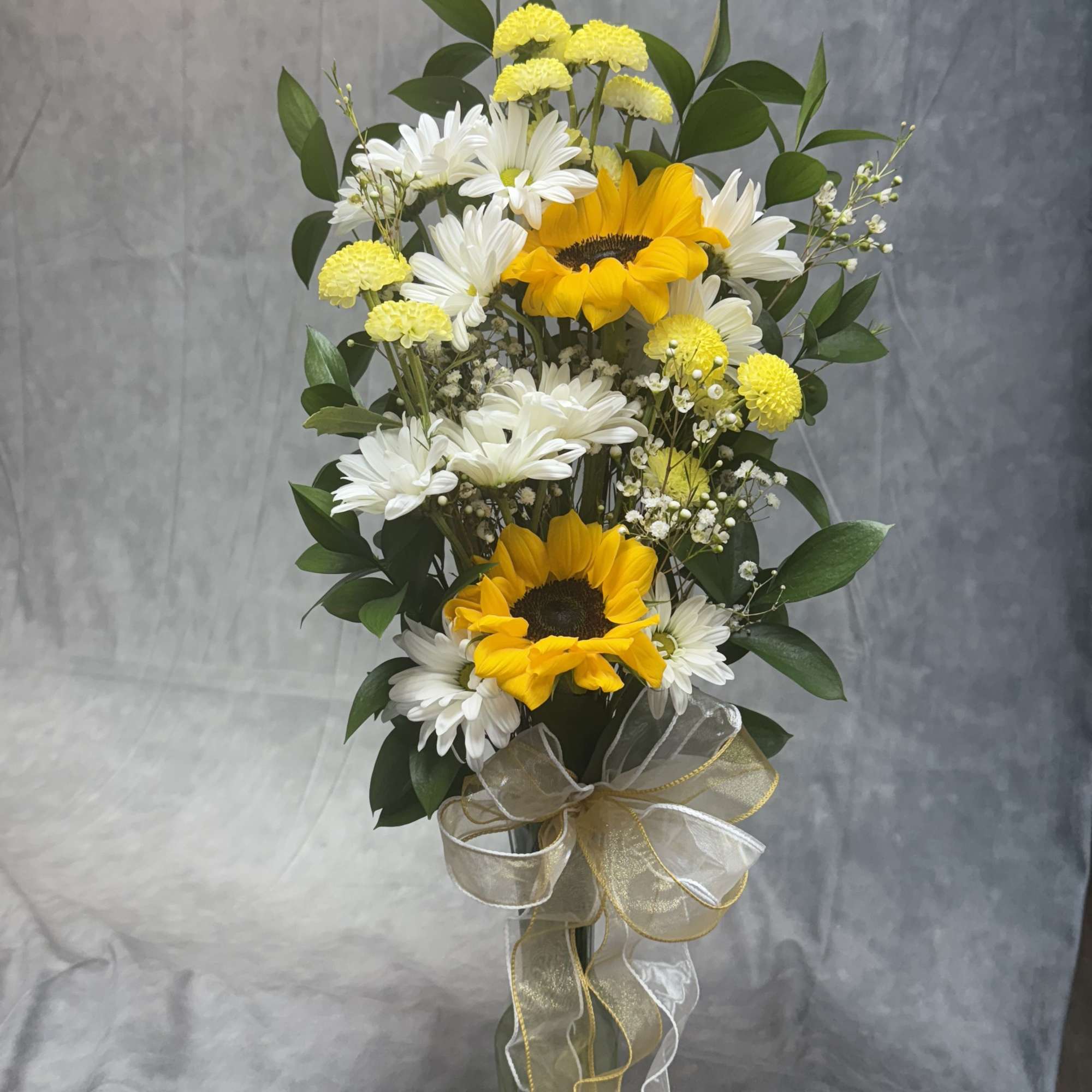 Sunflower and white daisy arrangement in a glass vase with ribbon