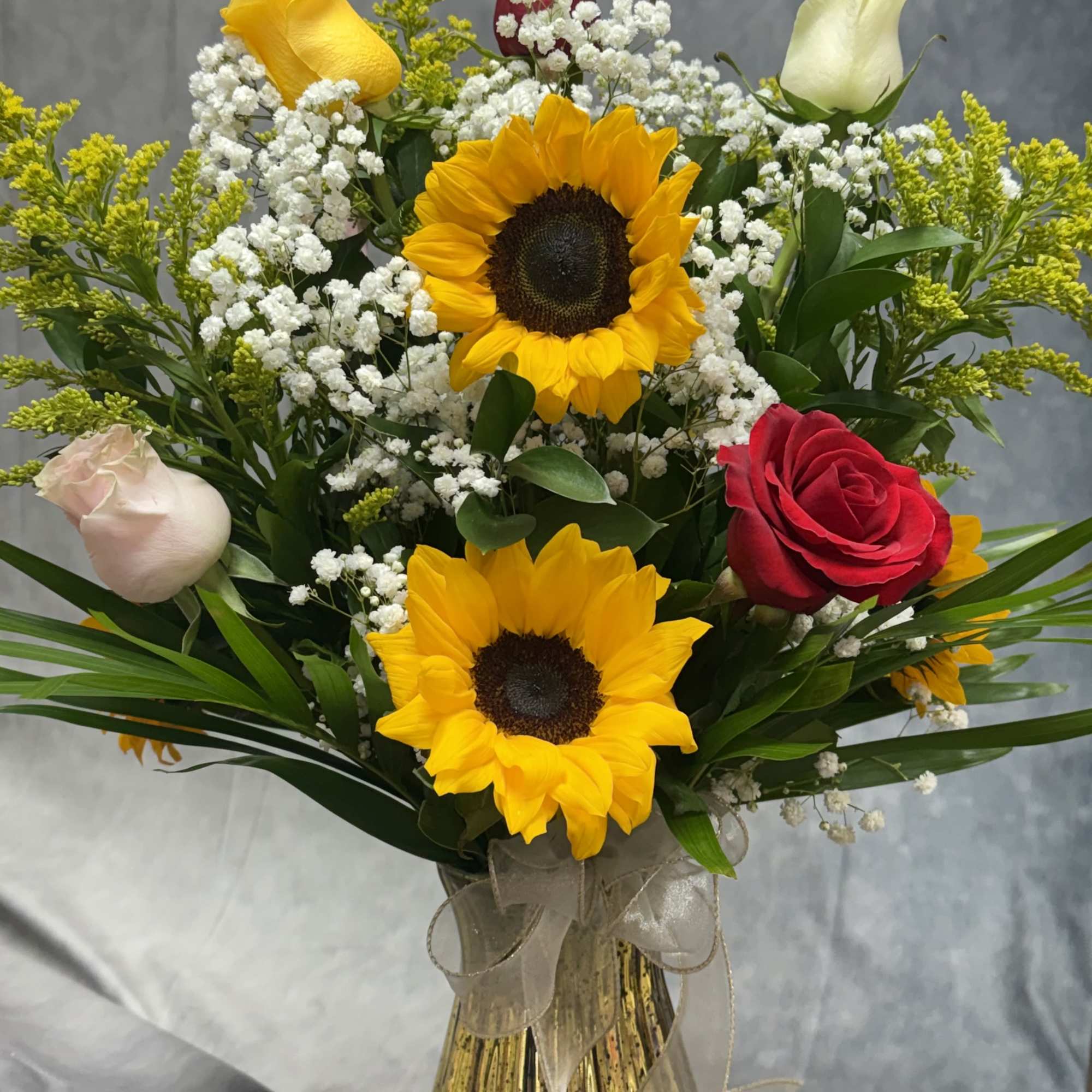 Bouquet of sunflowers and roses in a glass vase