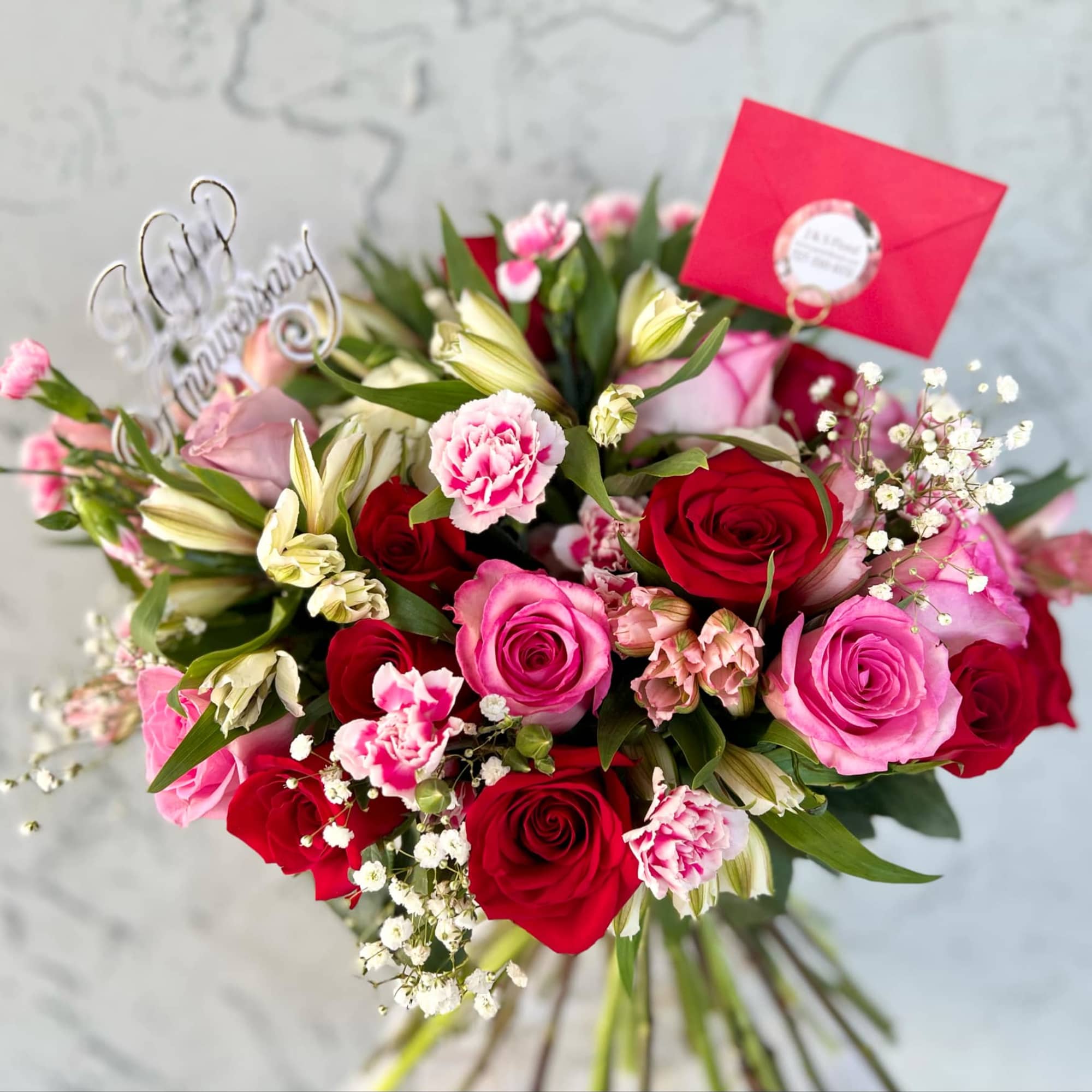 Bouquet of red and pink roses with small white filler flowers