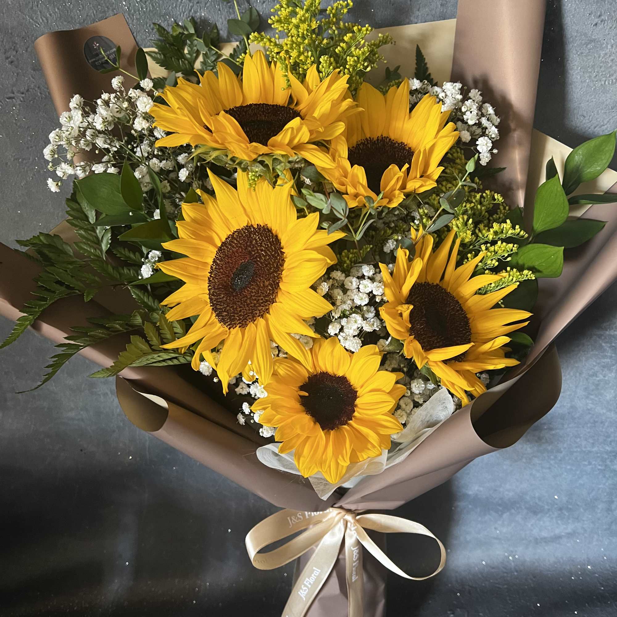 Bouquet of sunflowers with baby's breath in brown wrapping
