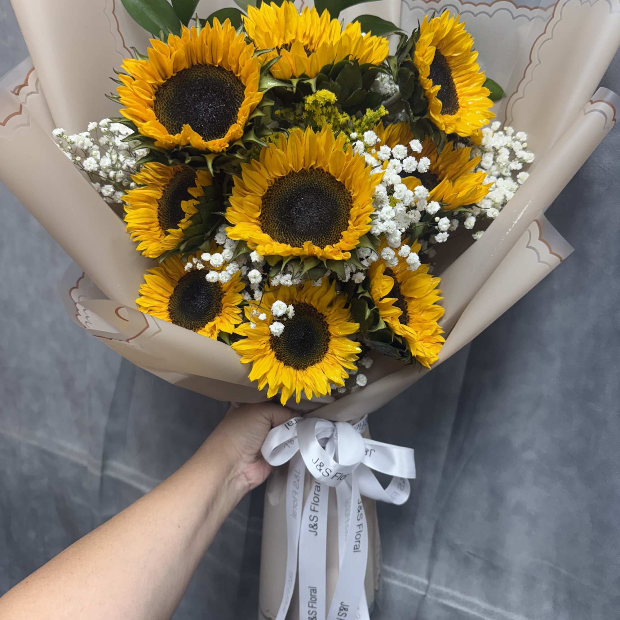 Bouquet of sunflowers with white baby's breath in tan wrap