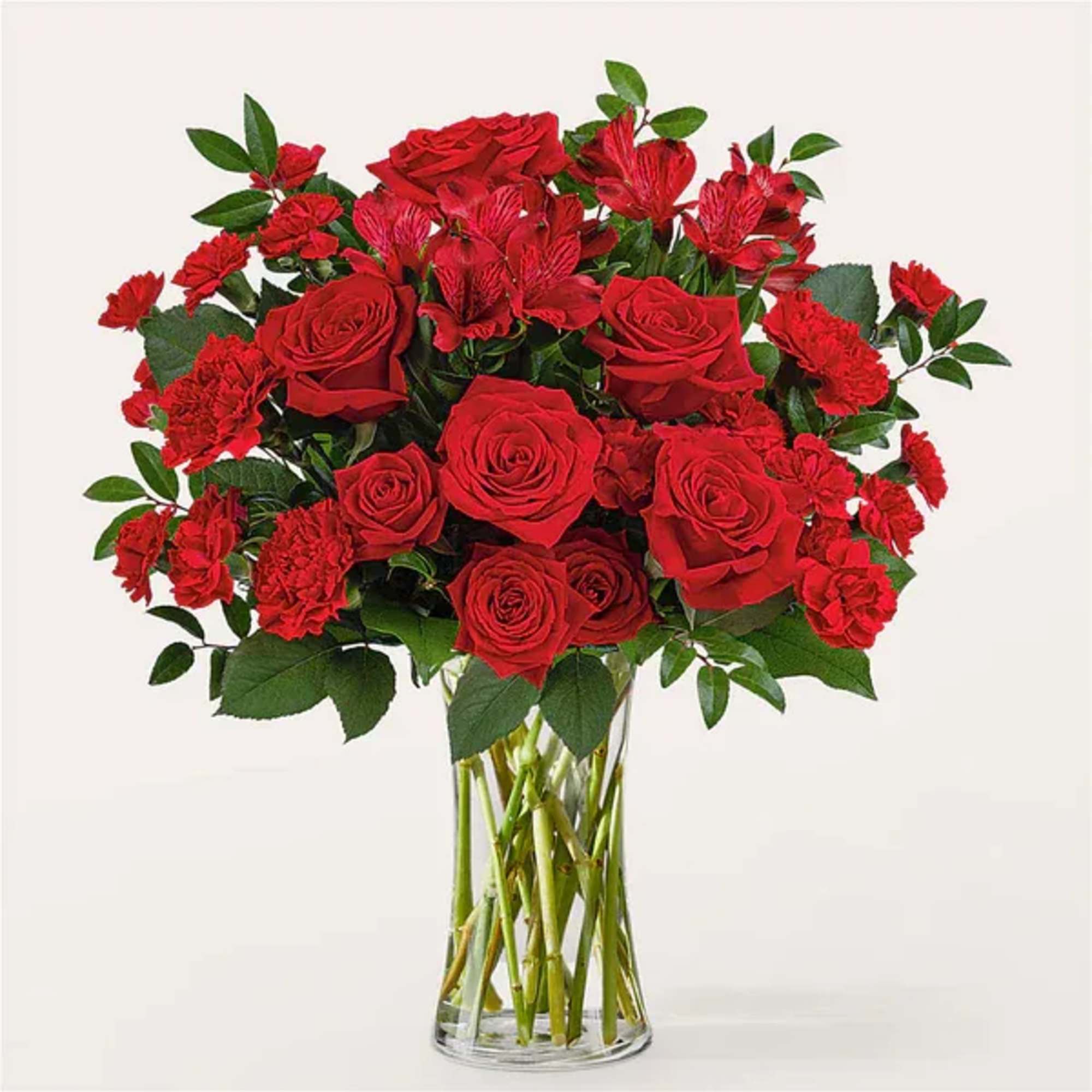 Red roses and carnations in a clear glass vase