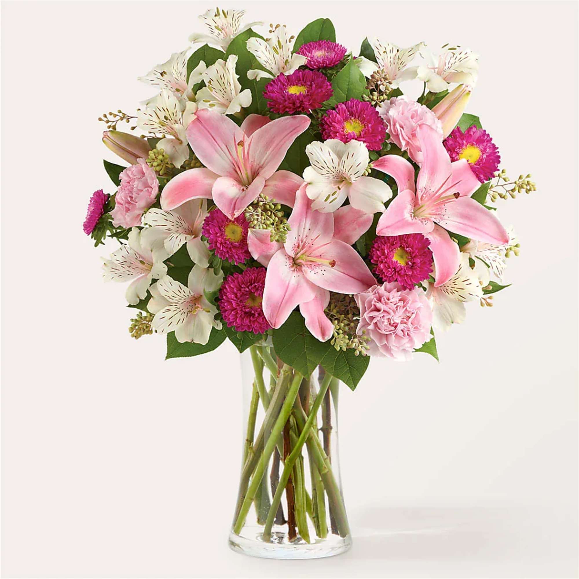Pink lilies and white alstroemeria in a clear glass vase