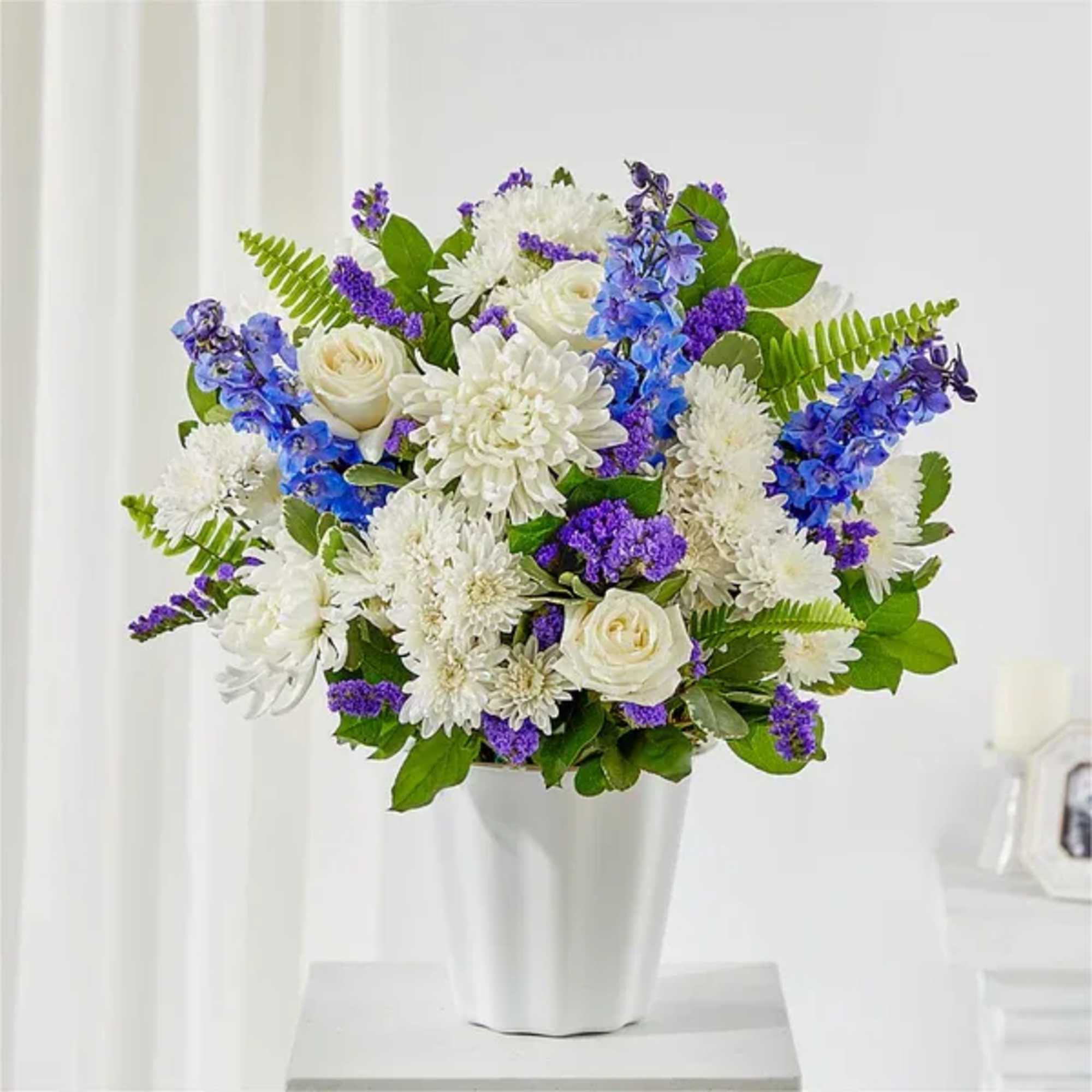 White and purple mixed bouquet in a white vase