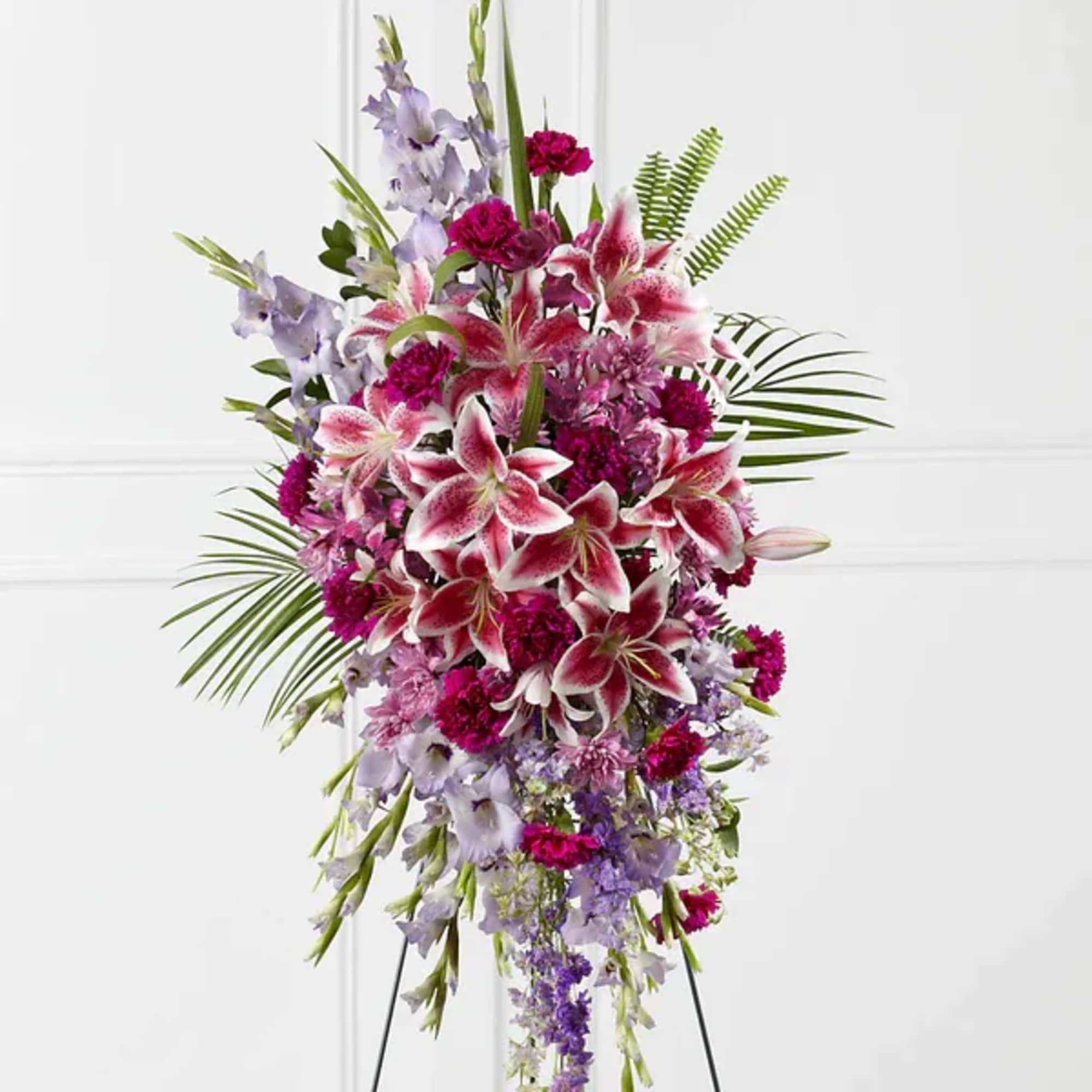Tall floral spray with pink lilies and purple flowers on a stand