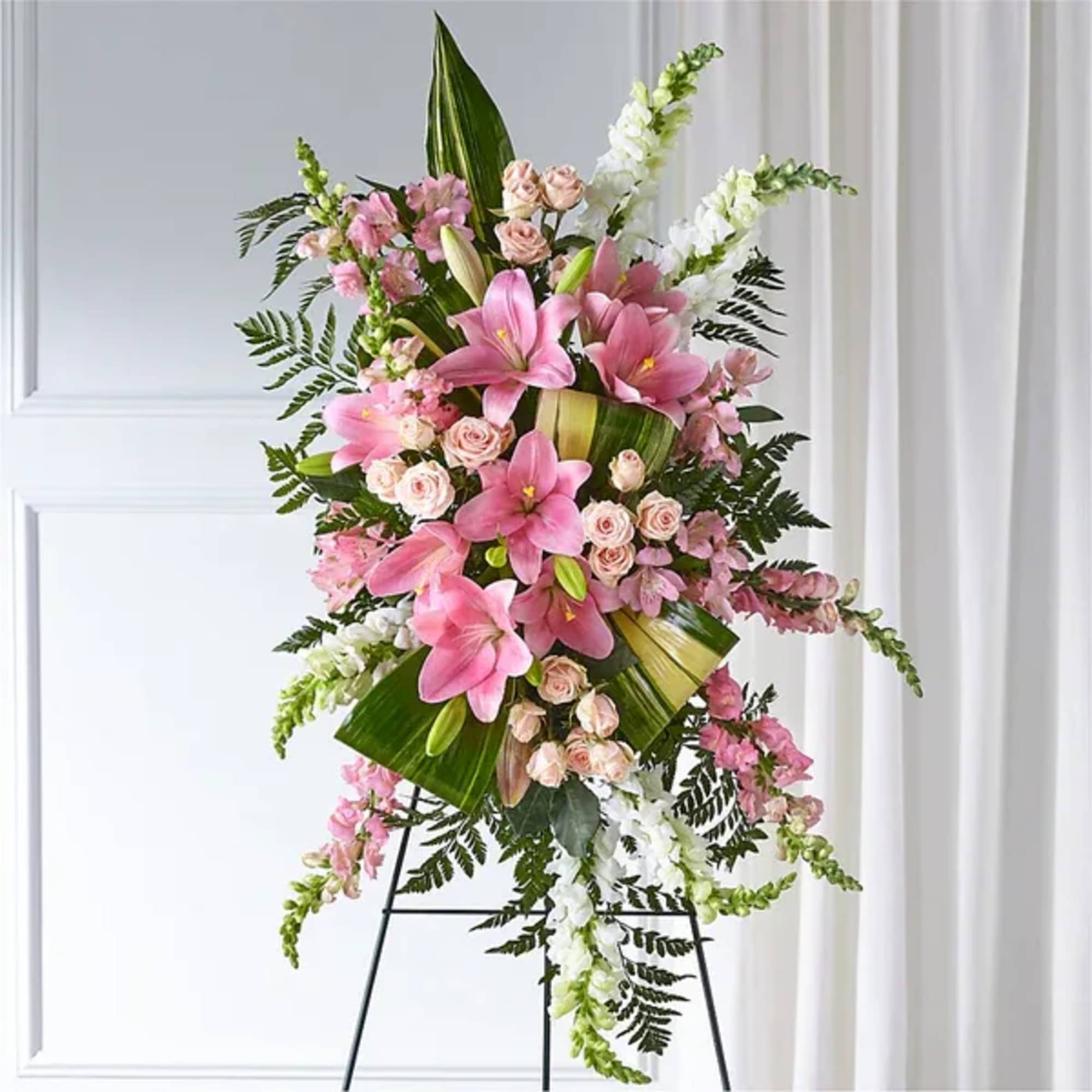 Tall pink and white floral standing spray on a black easel