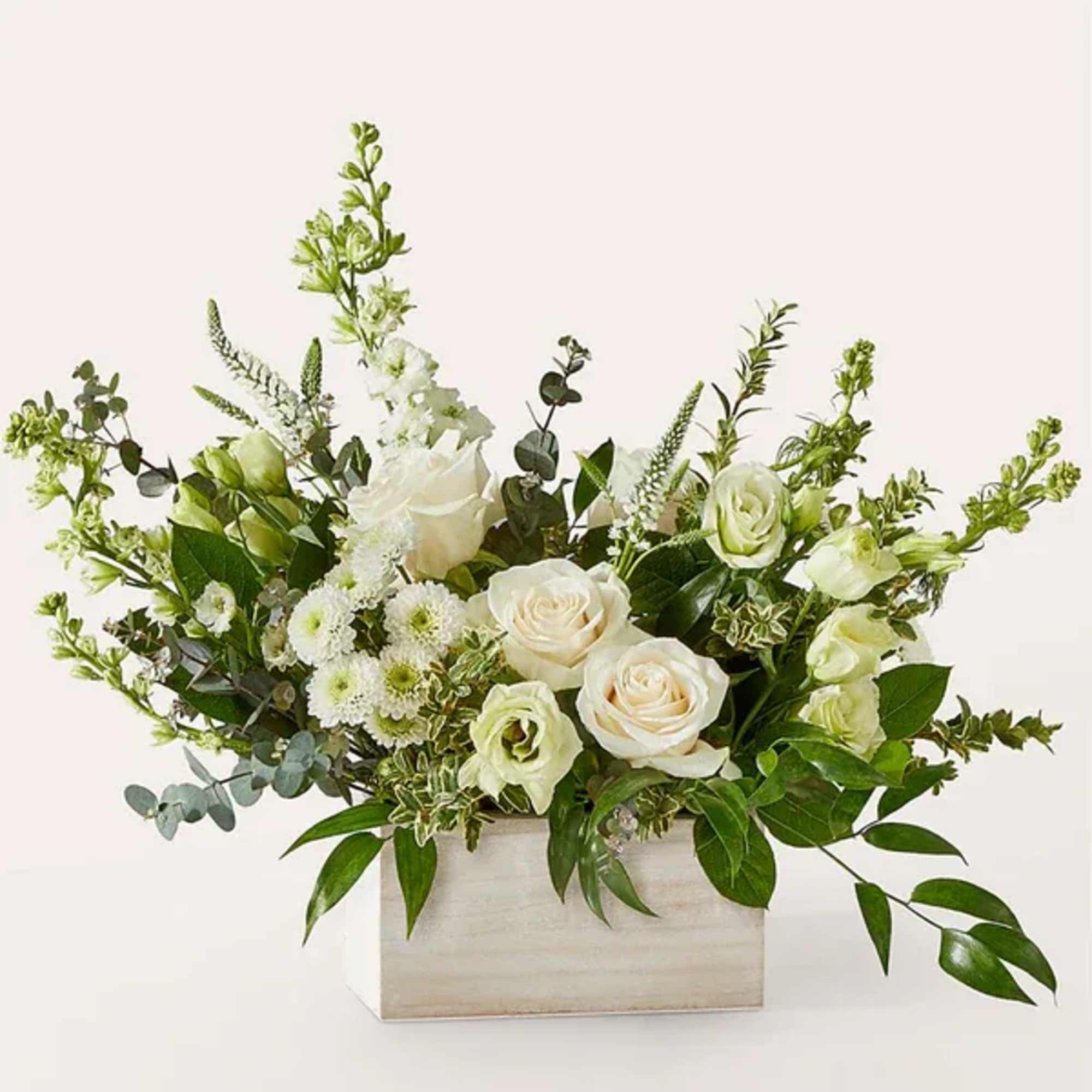 White roses and green blooms in a rectangular wooden box