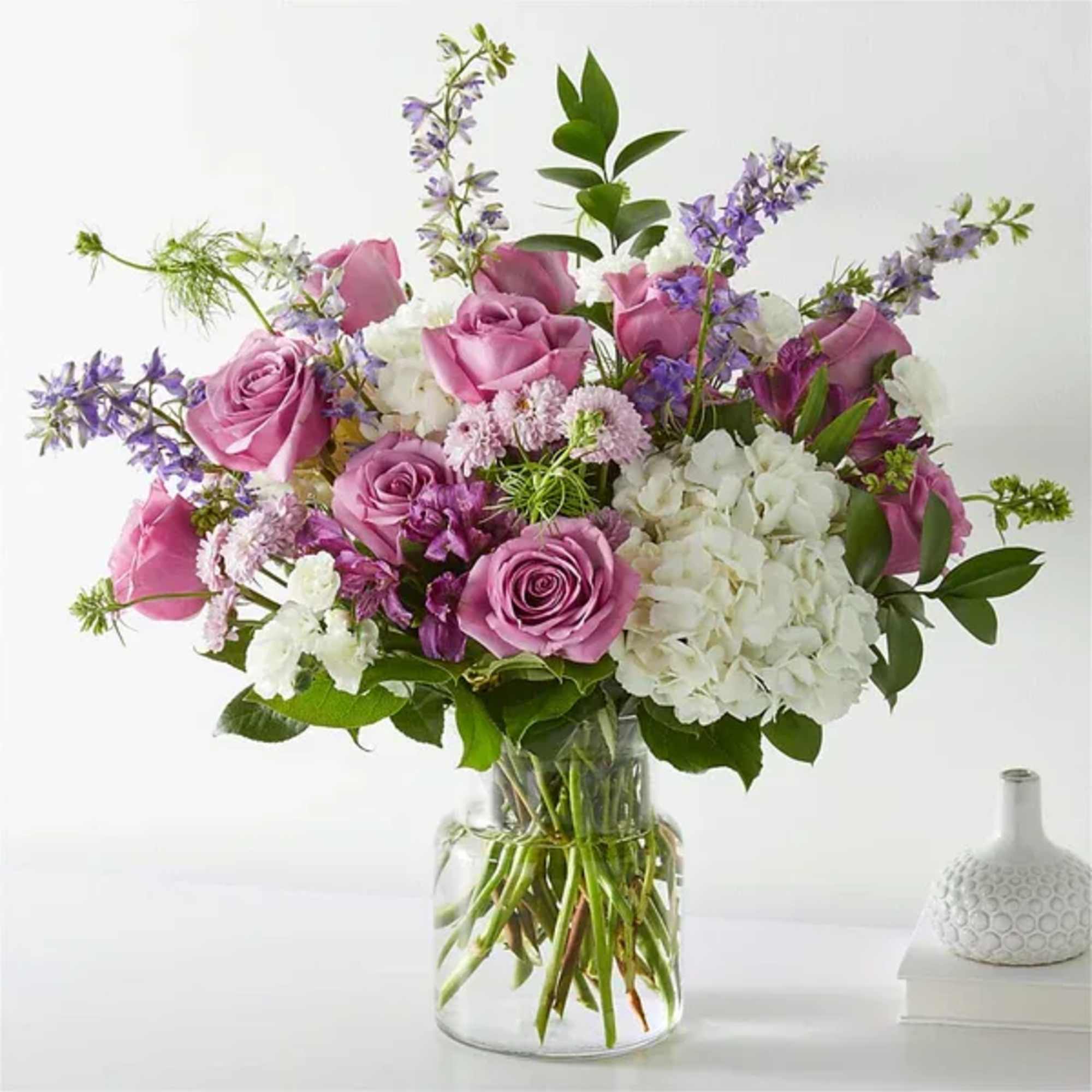 Pink roses and white hydrangeas in a clear glass vase